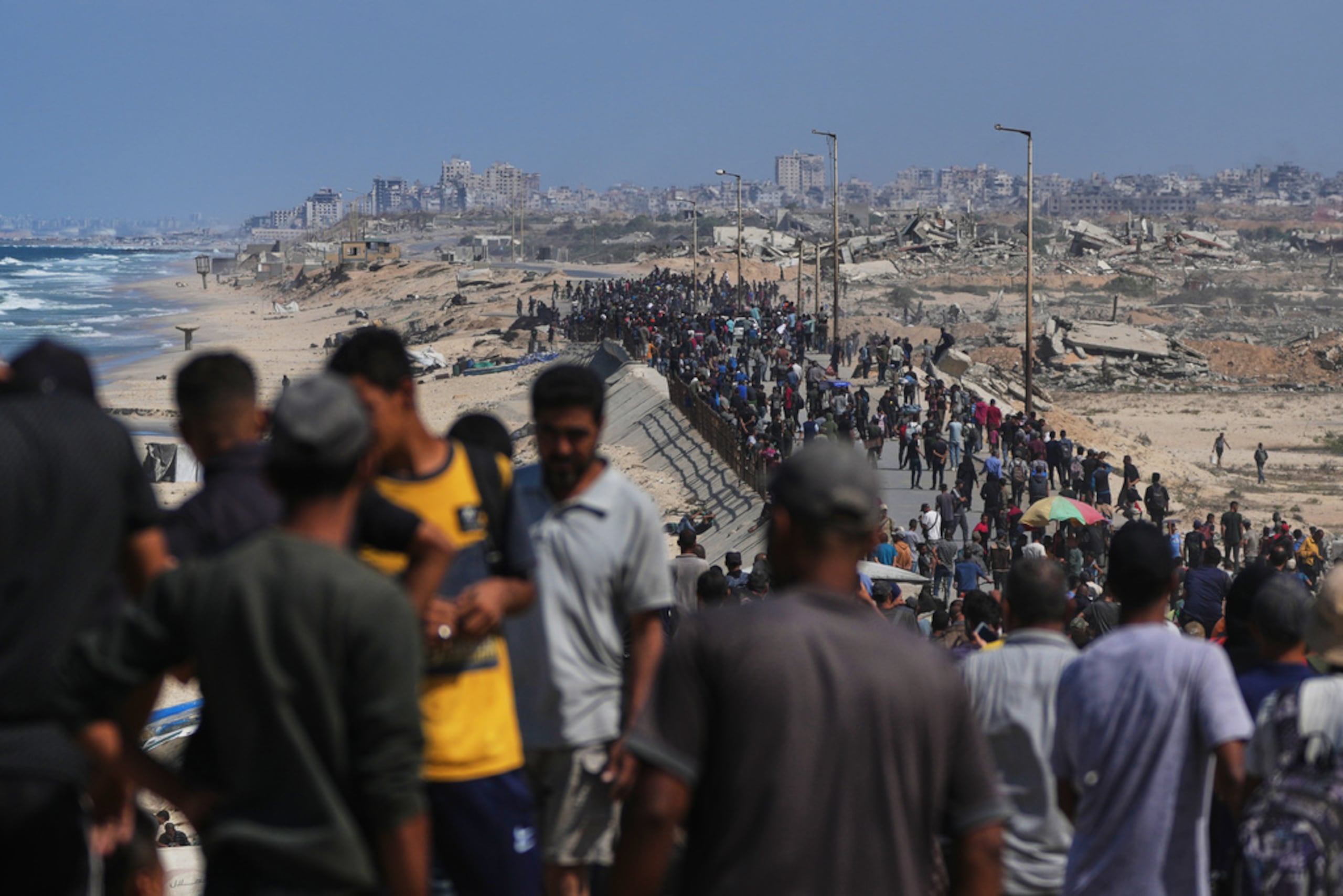 Palestinos desplazados caminan por la carretera costera cerca de Wadi Gaza, en la Franja de Gaza central, dirigiéndose hacia el norte de Gaza, el 10 de octubre de 2025, después de que Israel y Hamás acordaran una pausa en su guerra y la liberación de los rehenes restantes.