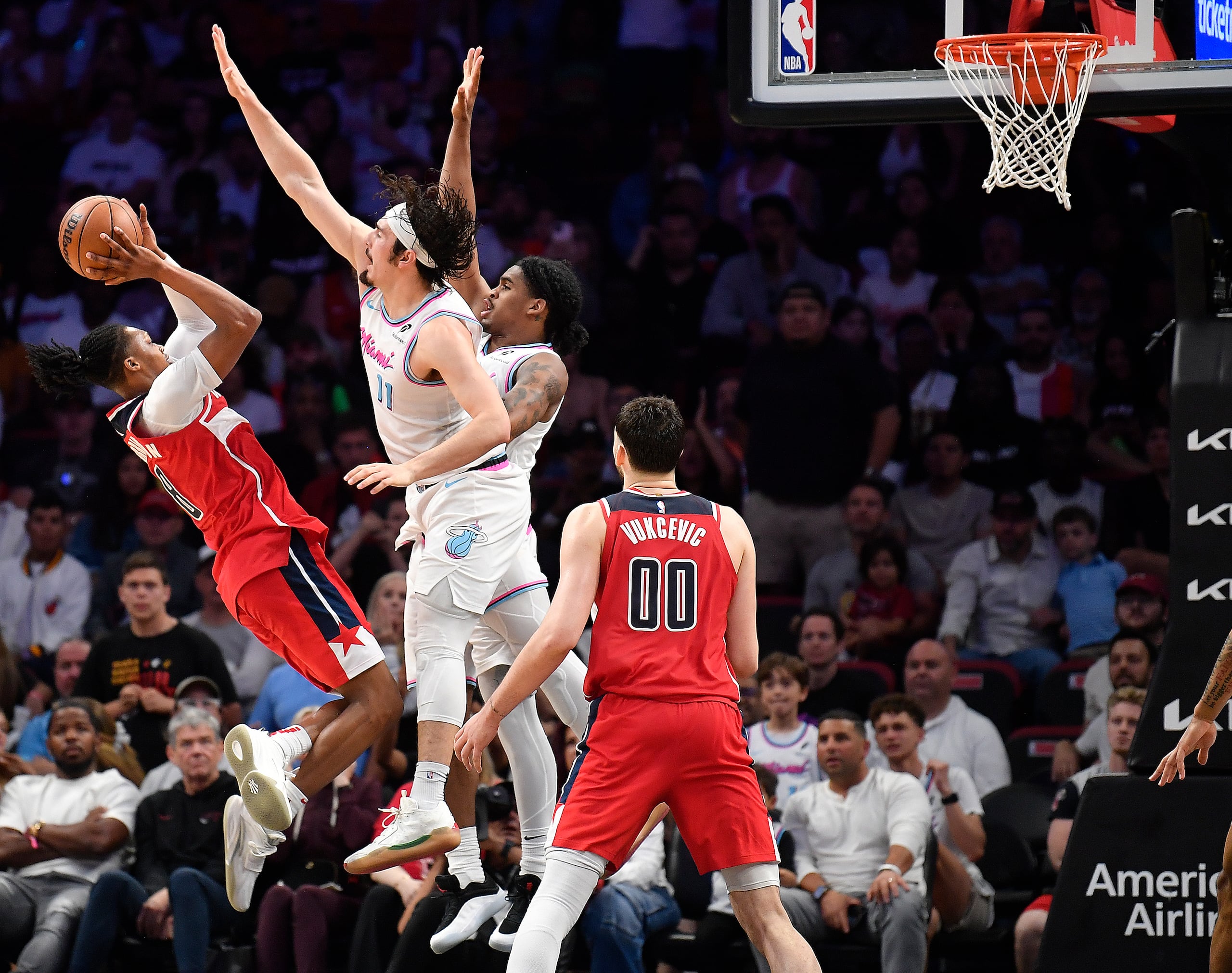 El base de los Wizards de Washington Bub Carrington lanza el tiro ganador frente a Jaime Jaquez Jr. y Josh Christopher del Heat de Miami el domingo 13 de abril del 2025. (AP Foto/Michael Laughlin)