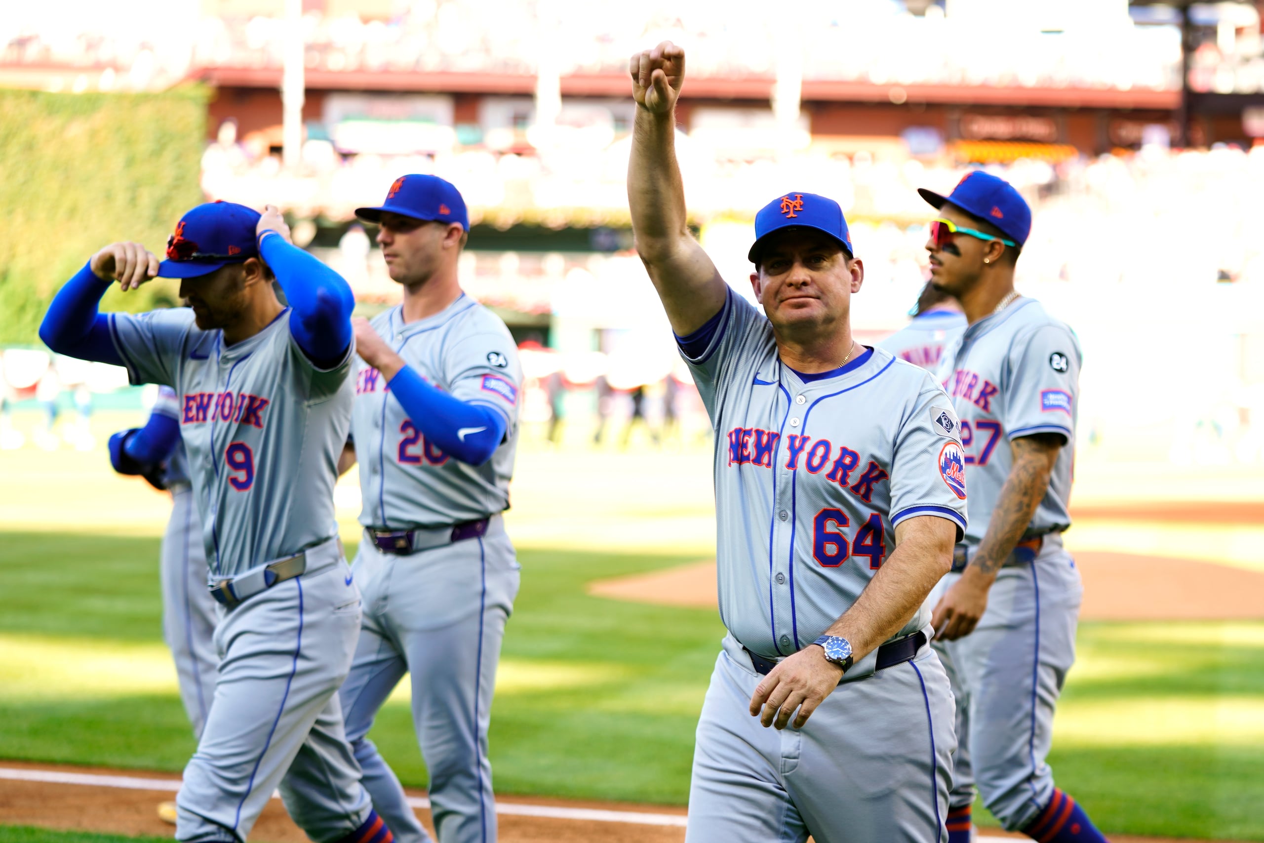El mánager de los Mets, Carlos Mendoza, a la derecha con el brazo levantado.