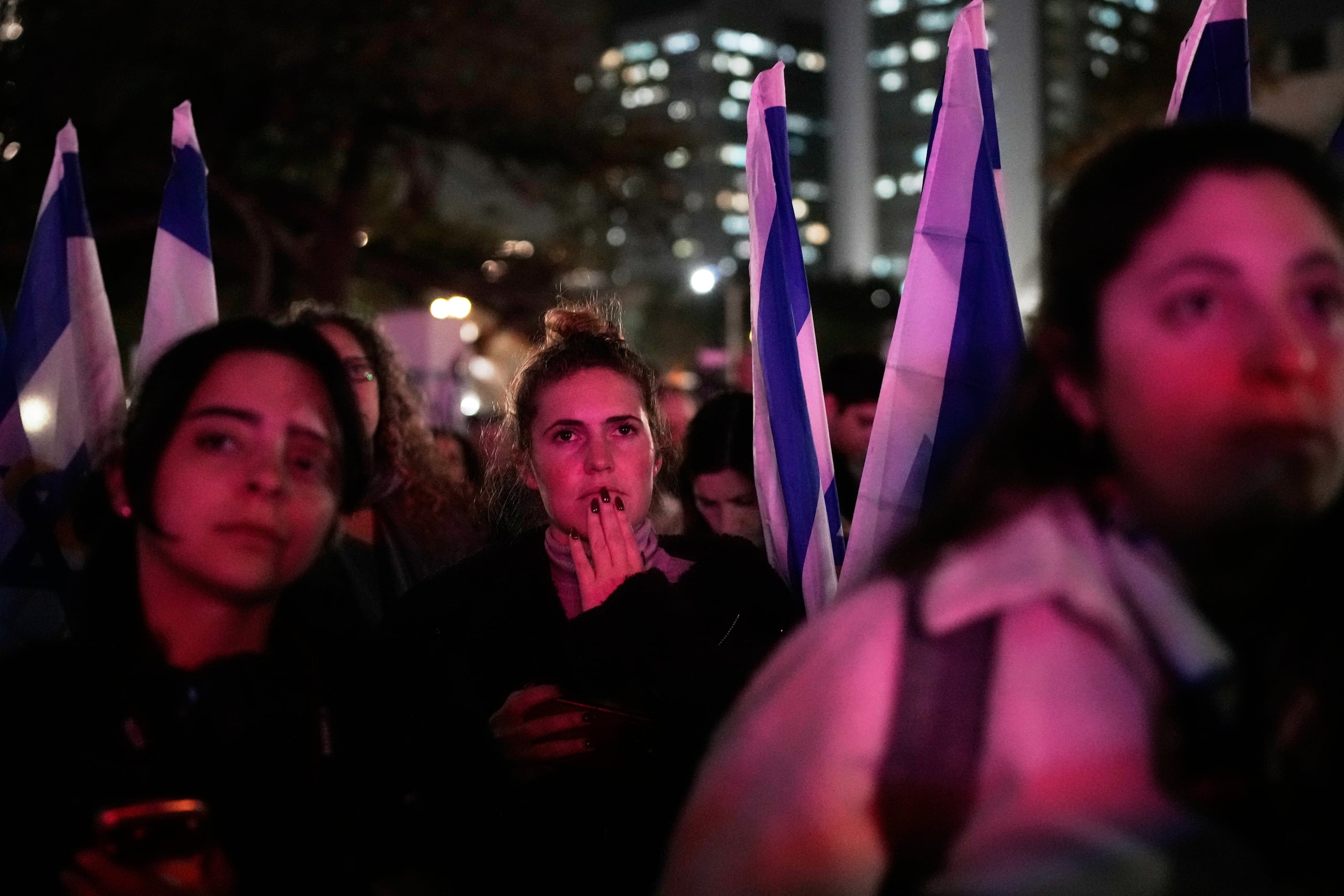 Un grupo de personas observa los últimos momentos en que una pantalla que mostraba el tiempo que pasó desde el ataque de Hamás, en la Plaza de los Rehenes, antes de que se apague, en Tel Aviv, Israel, el martes 27 de enero de 2026, un día después del regreso de los restos de Ran Gvili, el último rehén cautivo en Gaza. (AP Foto/Ohad Zwigenberg)