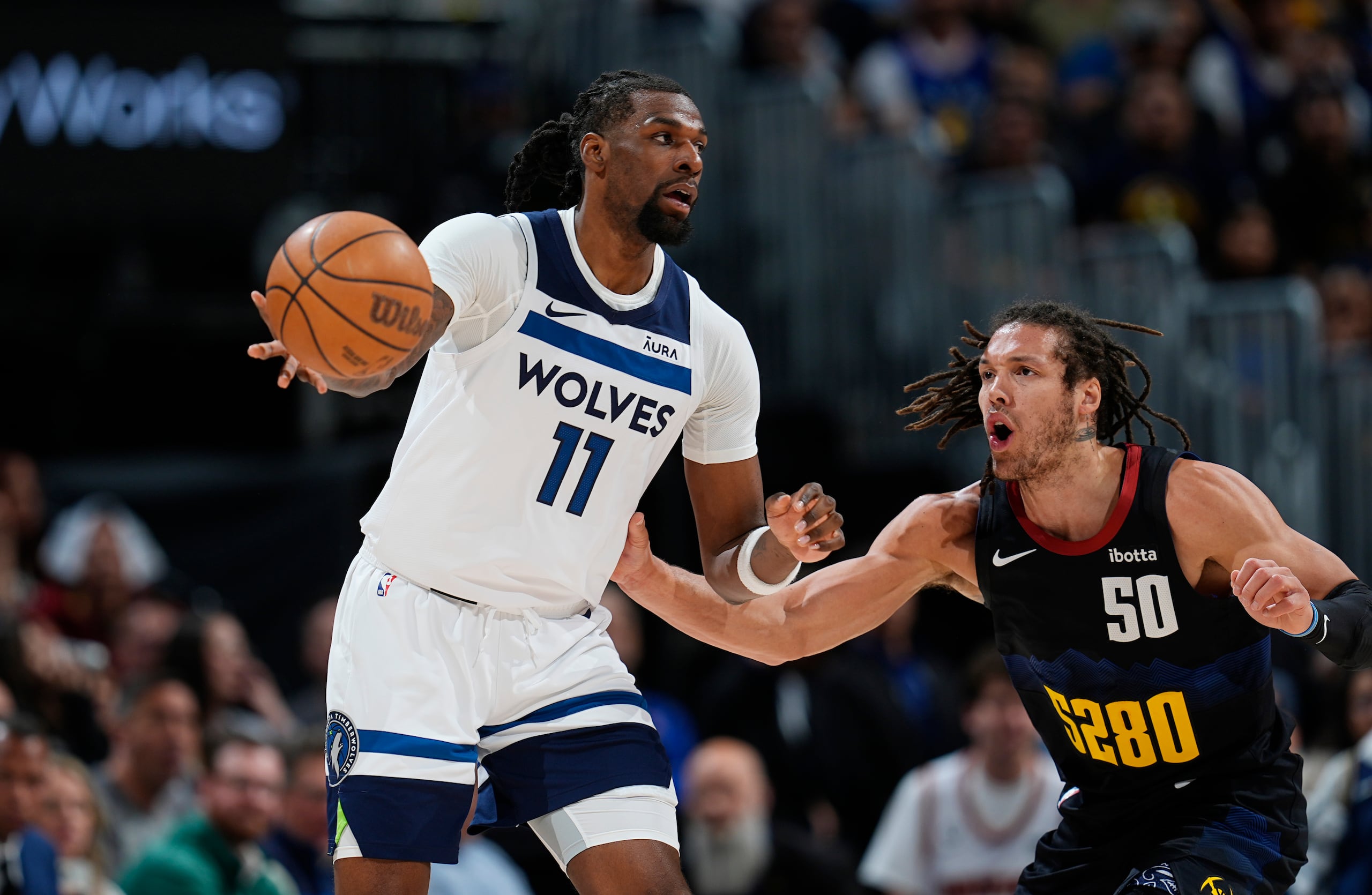 Naz Reid, izquierda, de los Timberwolves de Minnesota, pasa el balón mientra que Aaron Gordon, derecha, defiende en la primera mitad del Juego 2 de la serie de segunda ronda de playoffs del baloncesto de la NBA, el lunes 6 de mayo de 2024, en Denver.