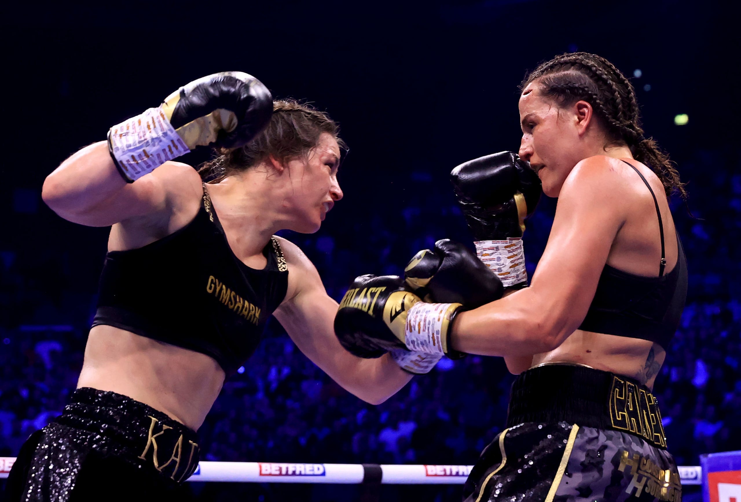 Katie Taylor lanza un golpe al rostro de Chantelle Cameron durante su combate por el campeonato indiscutible de peso superligero.