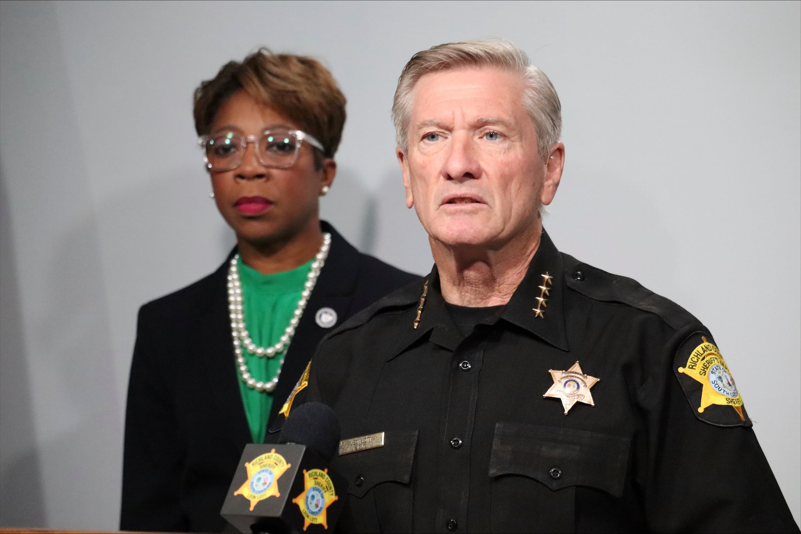 El jefe policial del condado Richland, Leon Lott, derecha, es acompañado por la concejal Gretchen Barron en una conferencia de prensa, el lunes 25 de septiembre de 2023 en Columbia, Carolina del Sur. (AP Foto/James Pollard)