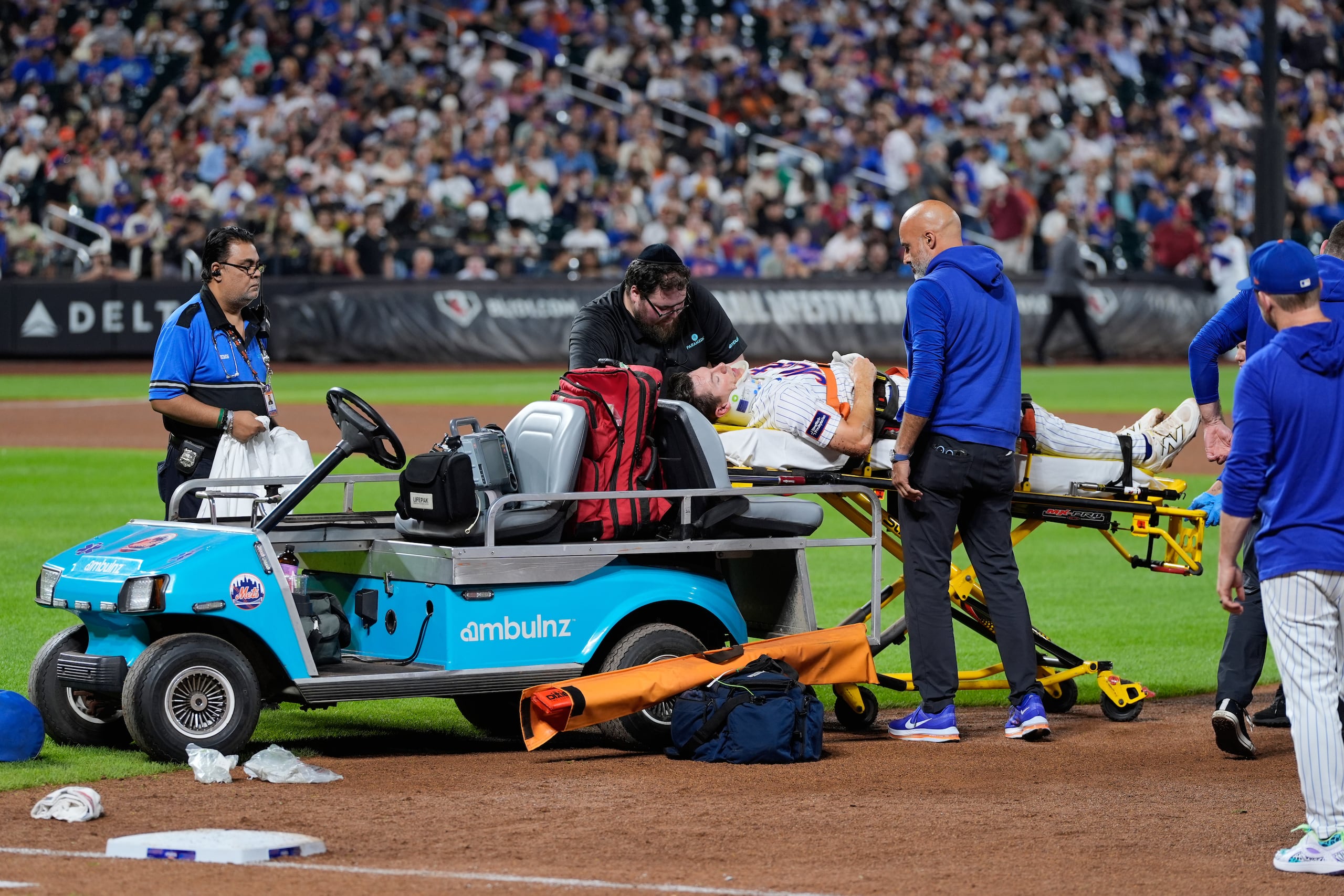 El inicialista de los Mets de Nueva York, Jared Young, es sacado del terreno en una camilla tras chocar con el lanzador Nolan McLean durante la sexta entrada de un partido de béisbol contra los Phillies de Filadelfia.