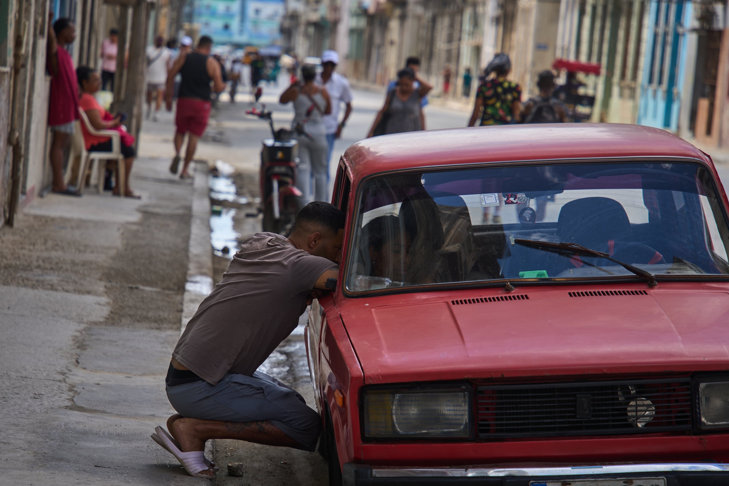 Un hombre habla con una persona dentro de un automóvil durante un apagón en La Habana, Cuba, el lunes 16 de marzo de 2026. (Foto AP/Ramón Espinosa)