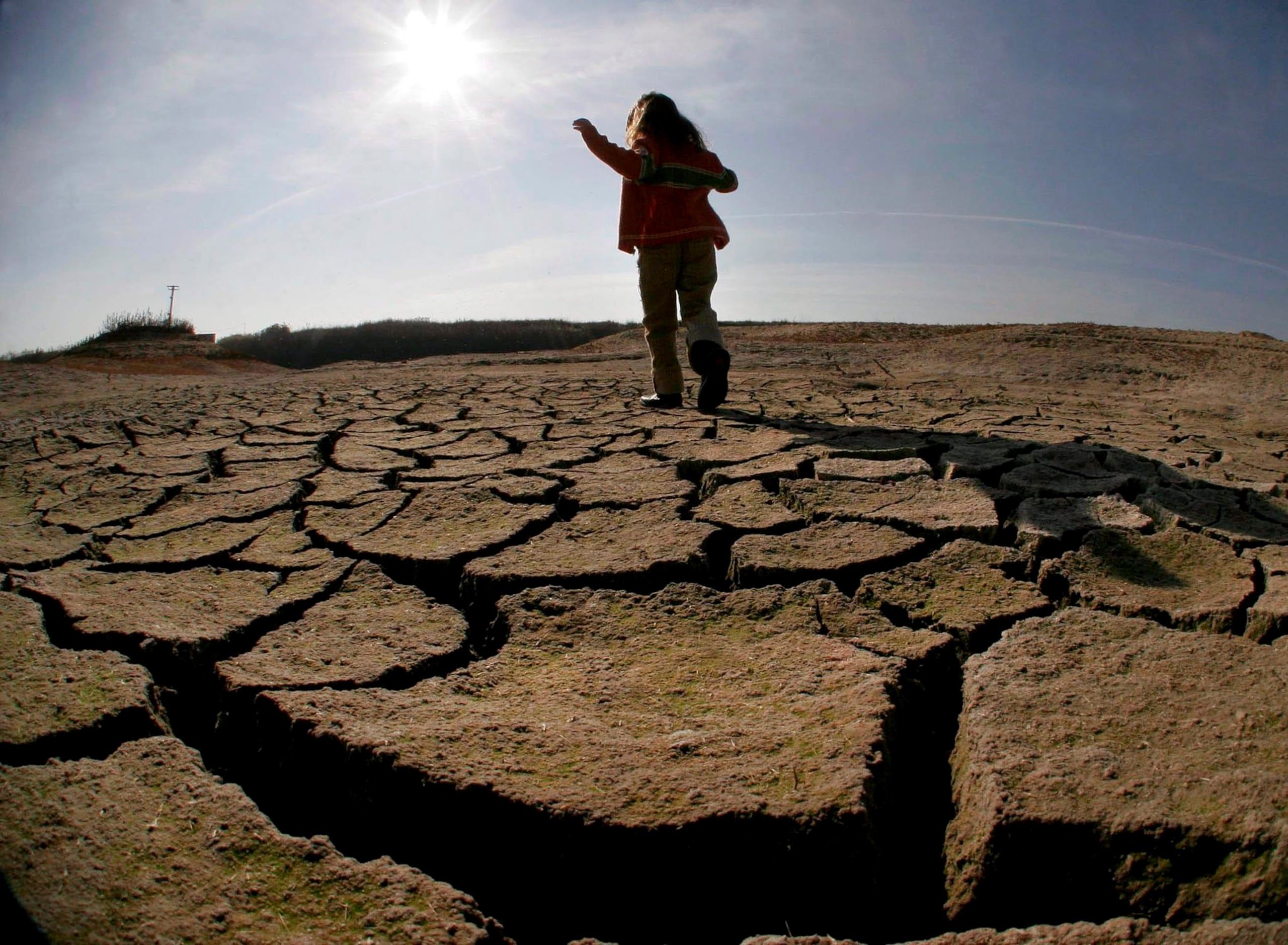En la imagen de archivo, una niña camina por terreno seco en lo que fue el llano verde de Thessalia, debido a la permanente sequía que afecta a Grecia. (EFE/Vassiliki Paschali)