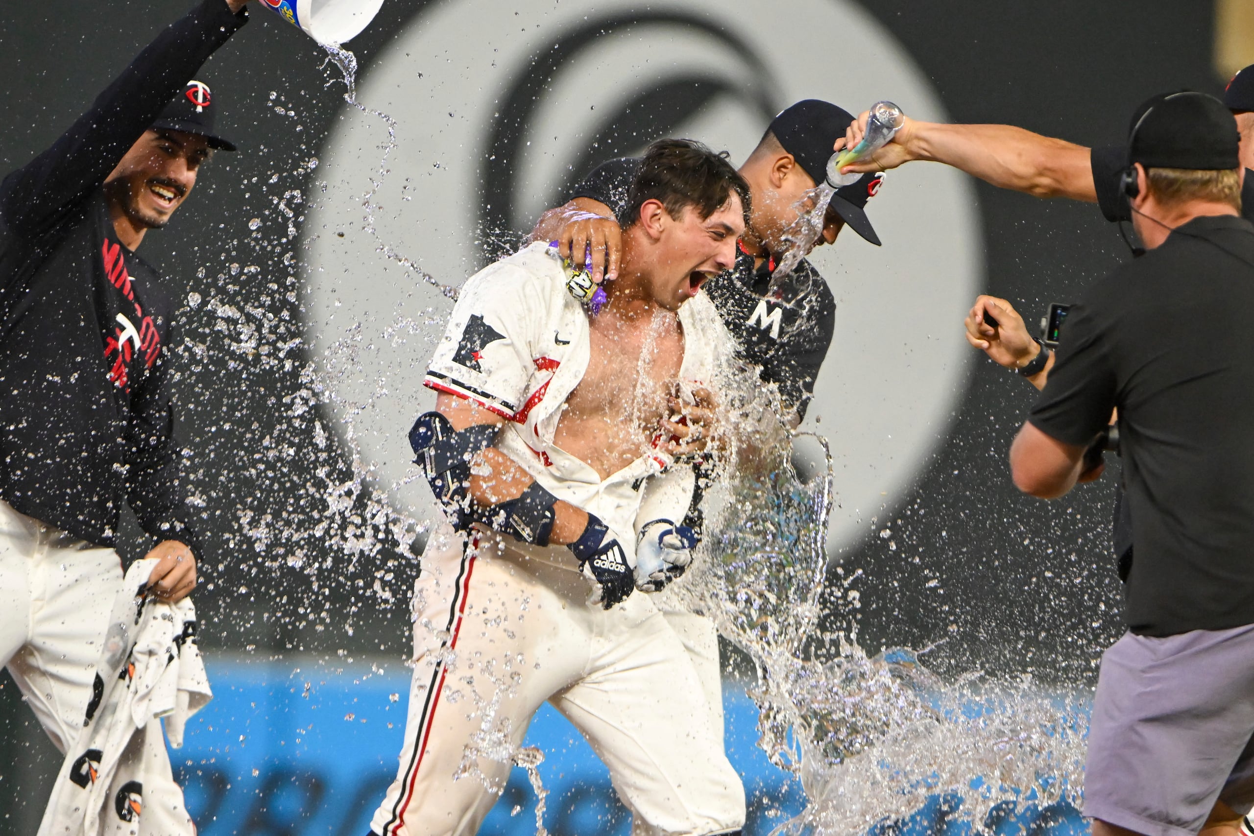 Brooks Lee, centro, de los Twins de Minnesota, recibe un baño por parte de sus compañeros de equipo después de batear un sencillo productor para dejar tendidos en el terreno a los Red Sox de Boston, el lunes 28 de julio de 2025, en Minneapolis. (AP Foto/Craig Lassig)