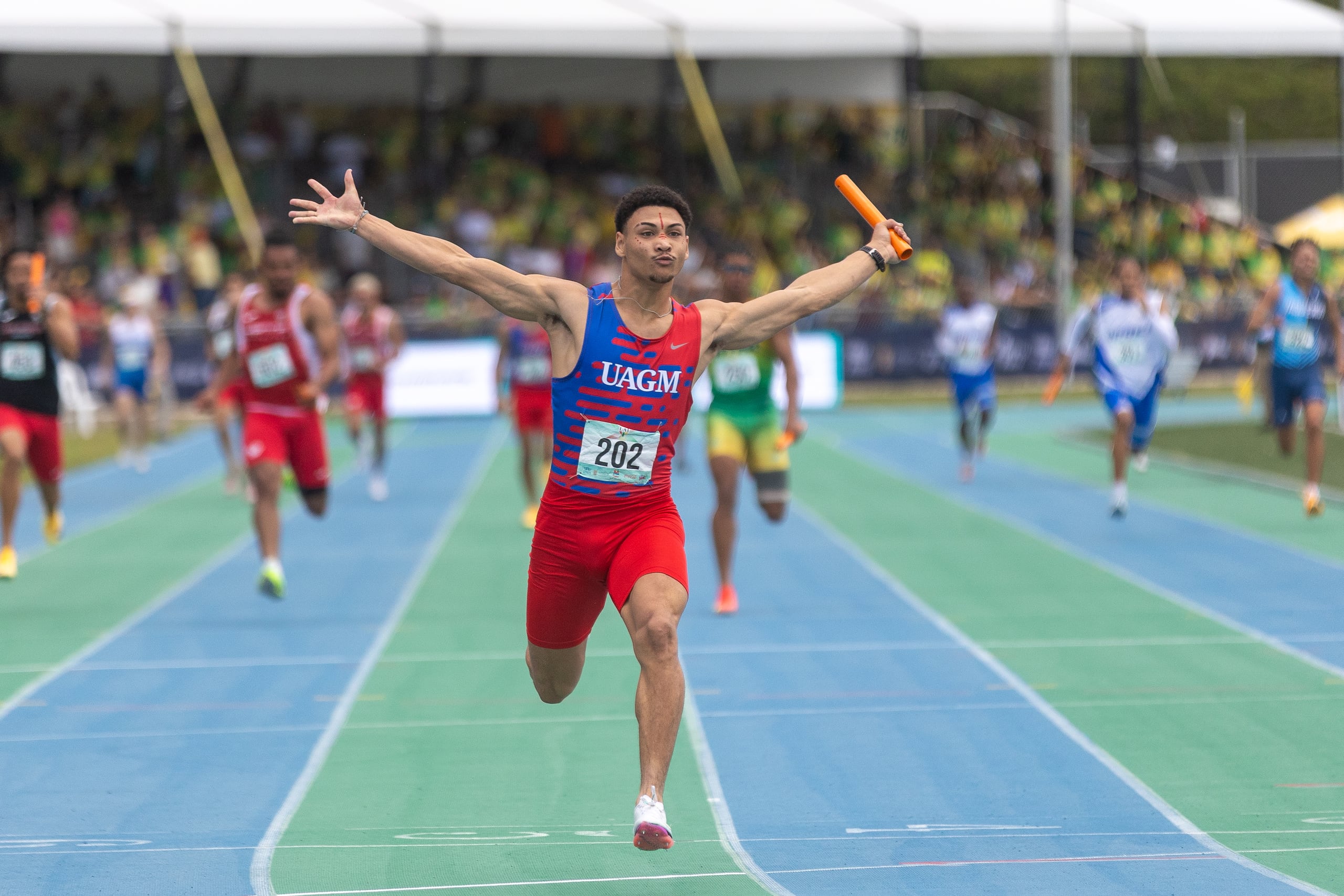 Yariel Pérez de la UAGM cruza la meta para fijar la nueva marca nacional y de las Justas en el relevo 4X100.