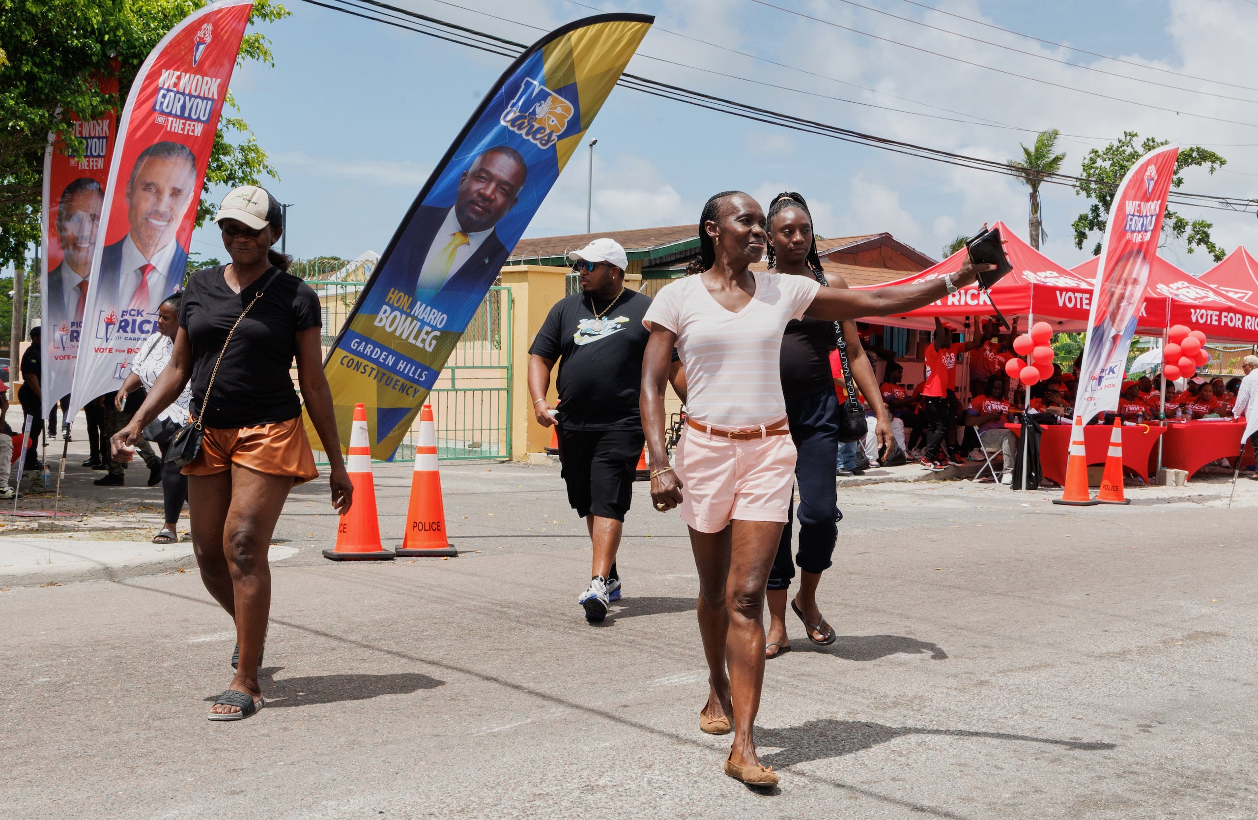 Varios votantes salen de un centro electoral en Garden Hills tras emitir su sufragio en una elección general en Nassau, Bahamas, el martes 12 de mayo de 2026. (AP Foto/Tim Aylen)