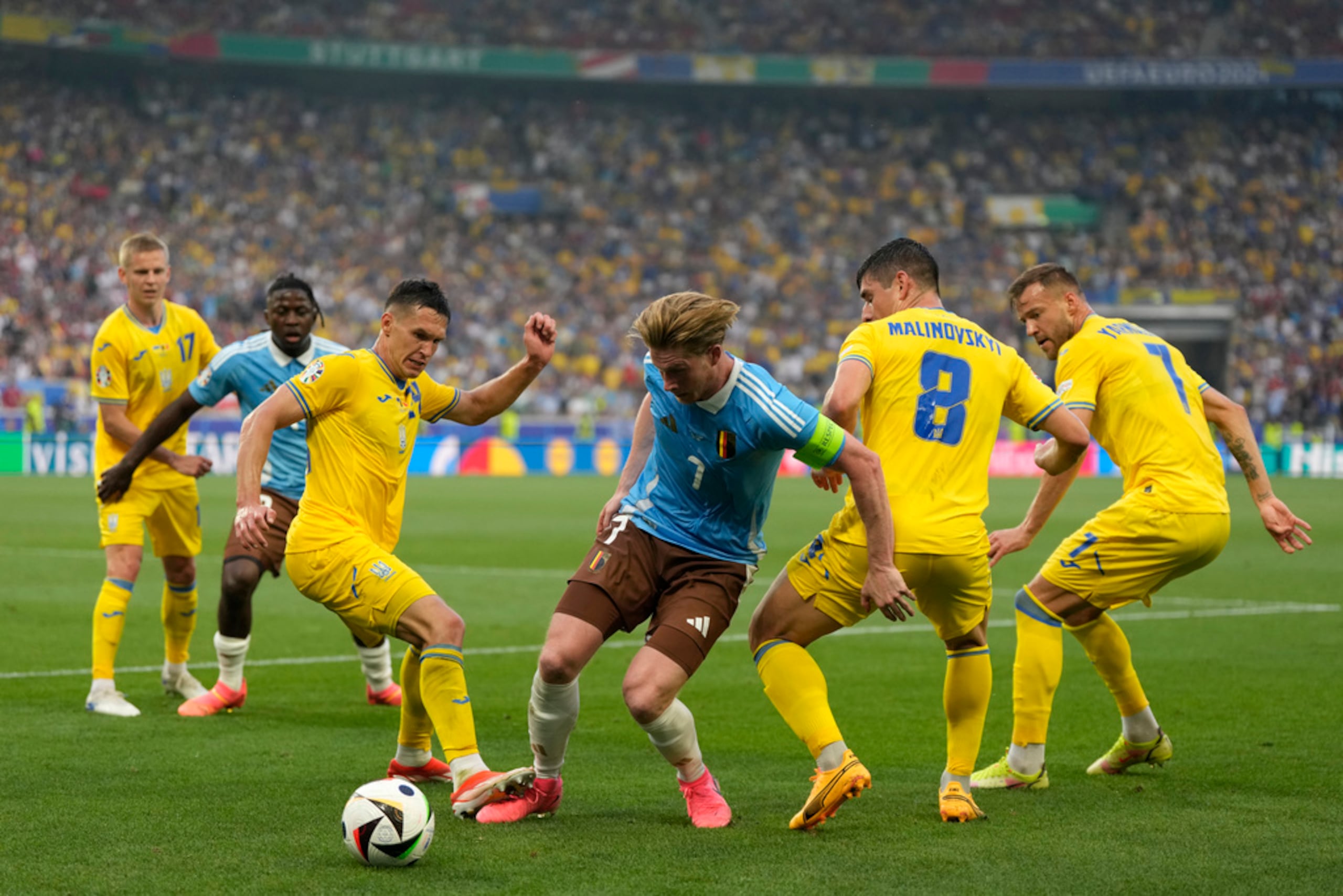 El belga Kevin De Bruyne pelea por mantener el control del balón entre los ucranianos Ruslan Malinovskyi y Andriy Yarmolenko en el encuentro del Grupo E de la Eurocopa.