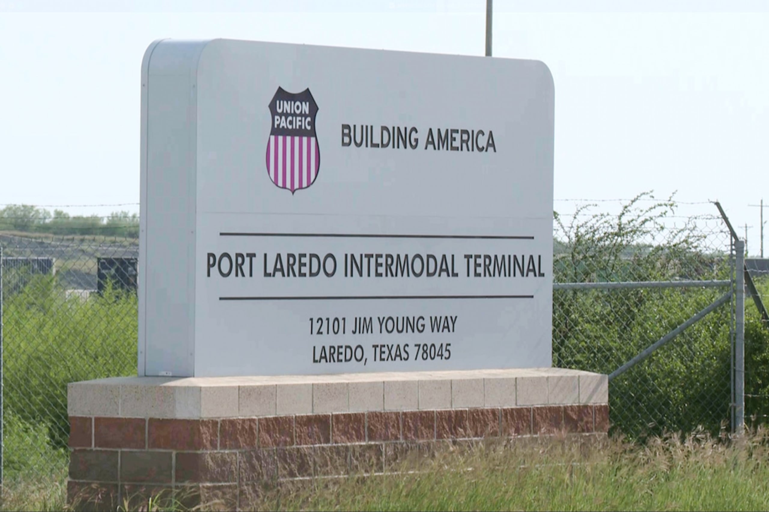 En esta imagen tomada de video proporcionado por KGNS, el letrero del Port Laredo Intermodal Terminal se ve afuera de un patio ferroviario en Laredo, Texas, el 10 de mayo de 2026.