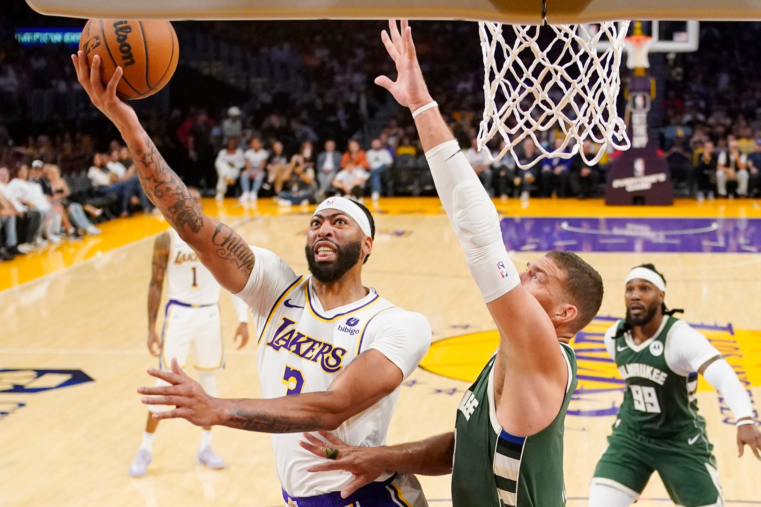 Anthony Davis, de los Lakers de Los Ángeles, ataca el canasto frente a la defensa de Brook López, de los Bucks de Milwaukee.
