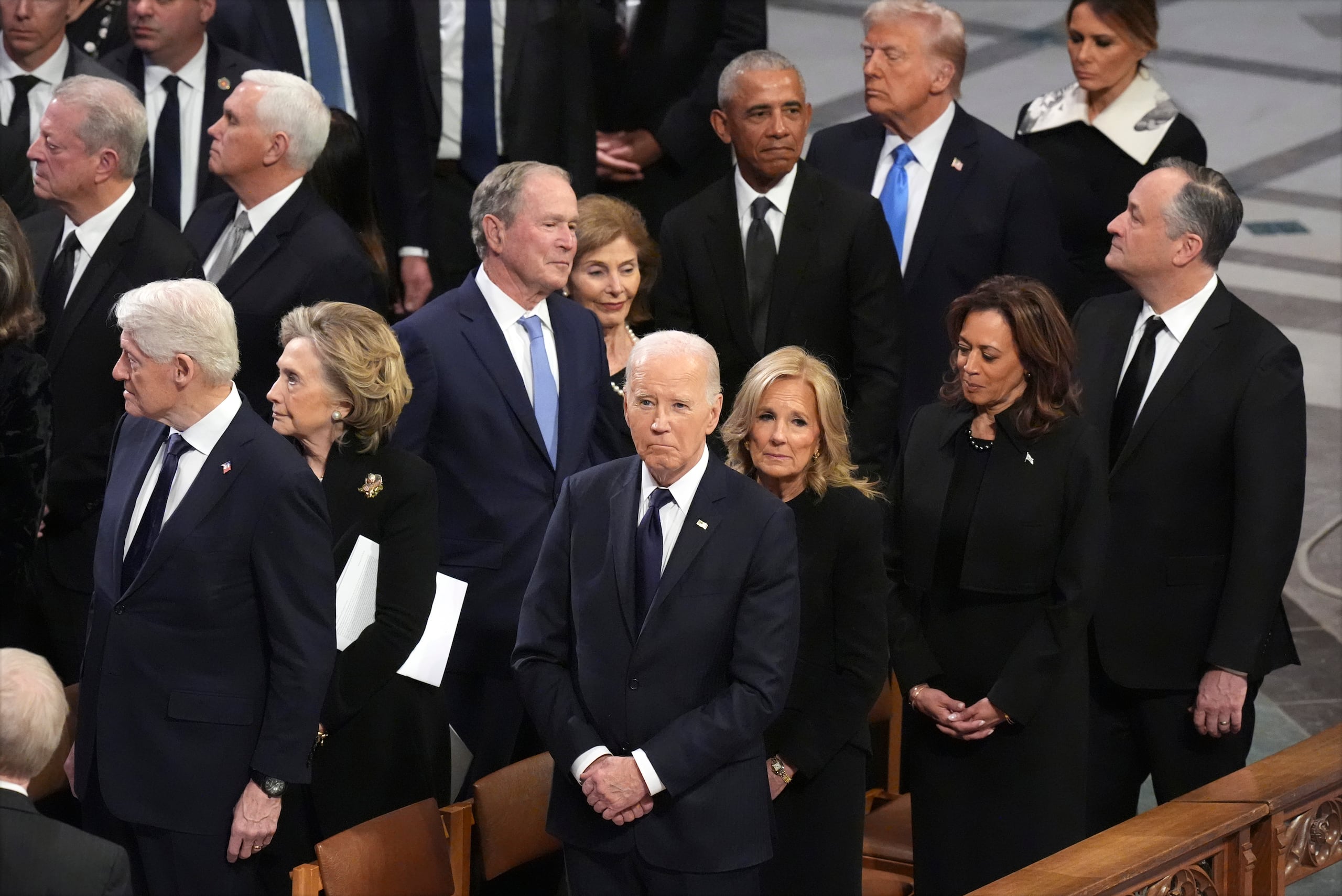 En primer plano, el presidente Joe Biden y la primera dama Jill Biden observan mientras inicia el funeral del expresidente Jimmy Carter, el jueves 9 de enero de 2025, en la catedral nacional de Washington. Detrás de Jill Biden se encuentran la vicepresidenta Kamala Harris y su esposo Doug Emhoff. En la siguiente fila están el expresidente Bill Clinton y su esposa Hillary Clinton; el expresidente George W. Bush y su esposa Barbara Bush; el expresidente Barack Obama, el presidente electo Donald Trump y su esposa Melania Trump. Arriba a la izquierda se encuentran el exvicepresidente Al Gore y, detrás de él, el exvicepresidente Mike Pence. (AP Foto/Jacquelyn Martin)