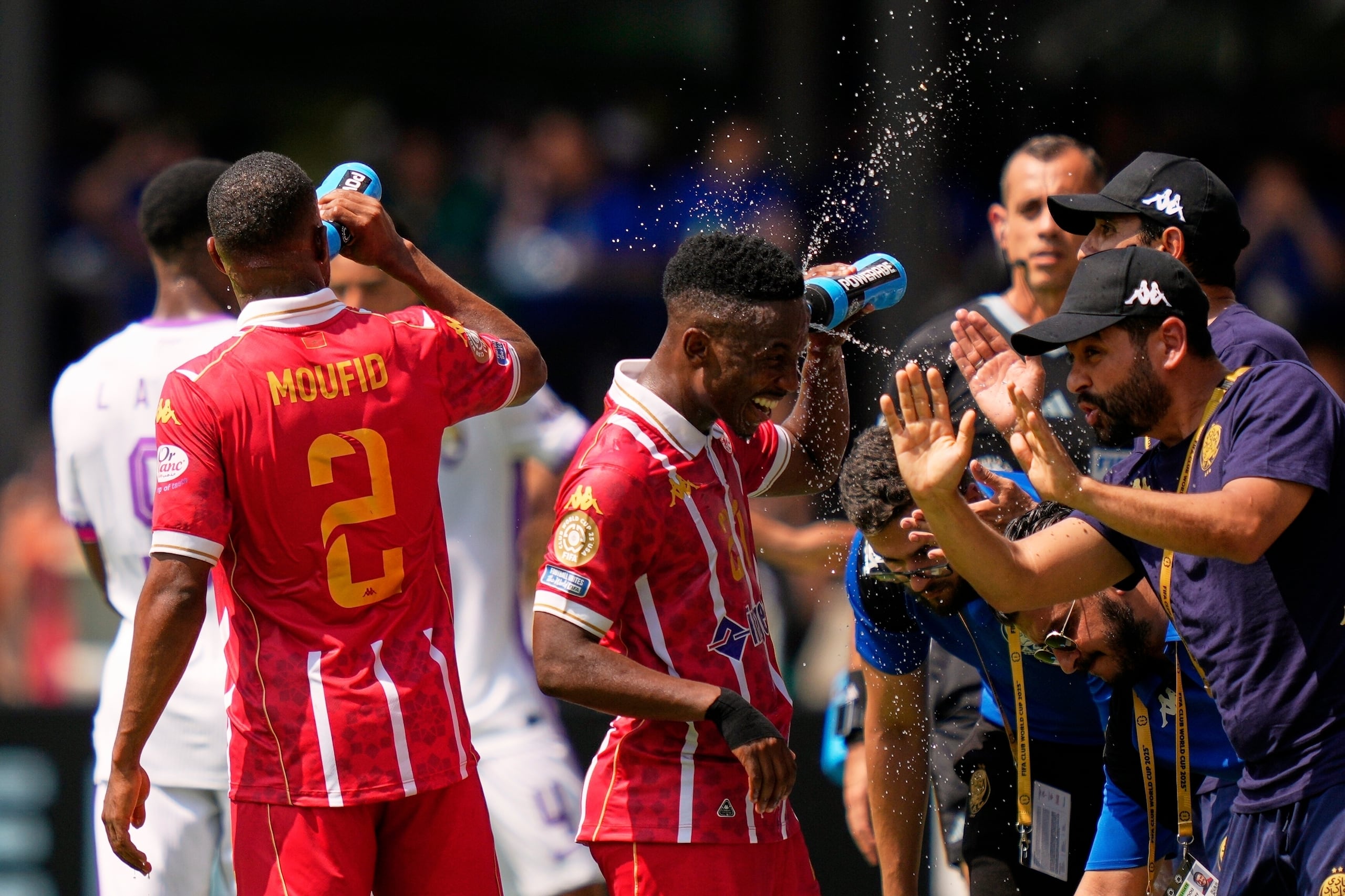 Cassius Mailula y Mohamed Moufid del Wydad de Marruecos se refrescan durante el partido contra Al Ain en el Mundial de Clubes.