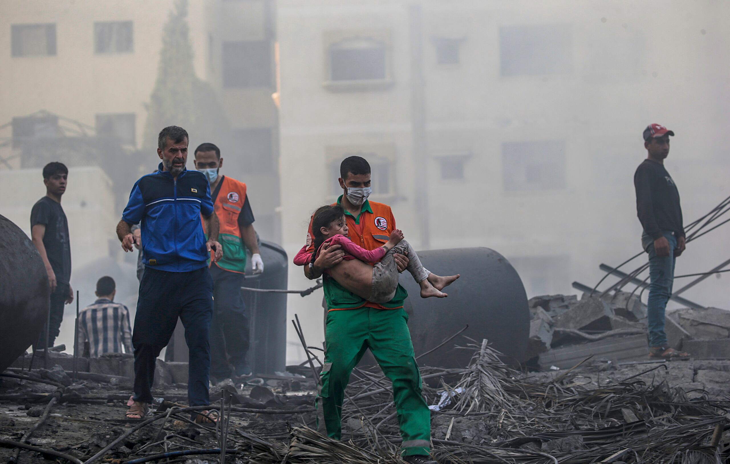 Un palestino carga a una niña herida tras recuperarla de los escombros de una zona destruida tras los ataques aéreos israelíes en la ciudad de Gaza. (EFE/EPA/MOHAMMED SABLE)