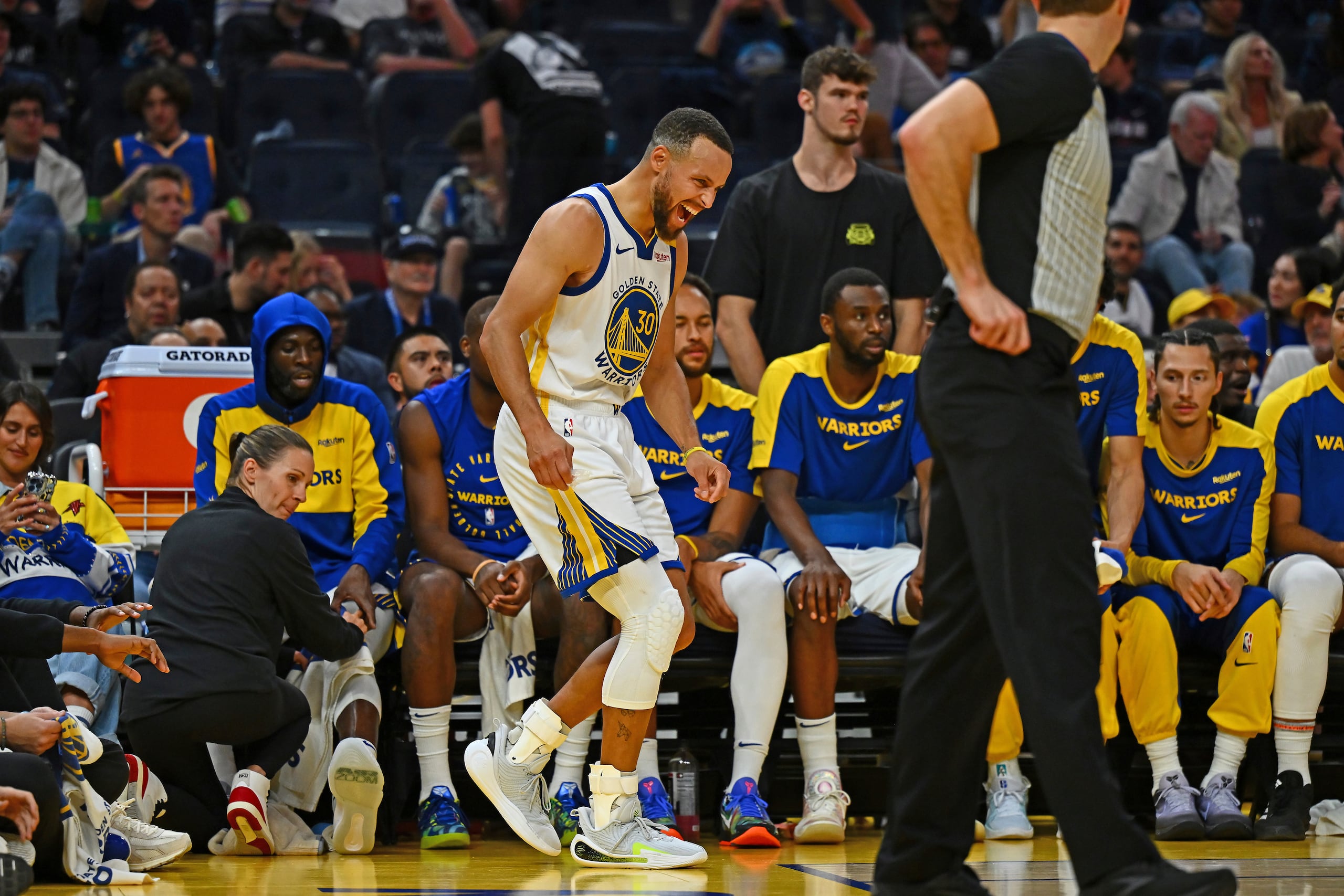 Stephen Curry, de Golden State, gesticula una molestía con el tobillo que se lastimó el domingo y que dejará inactivo al estrella anotador.