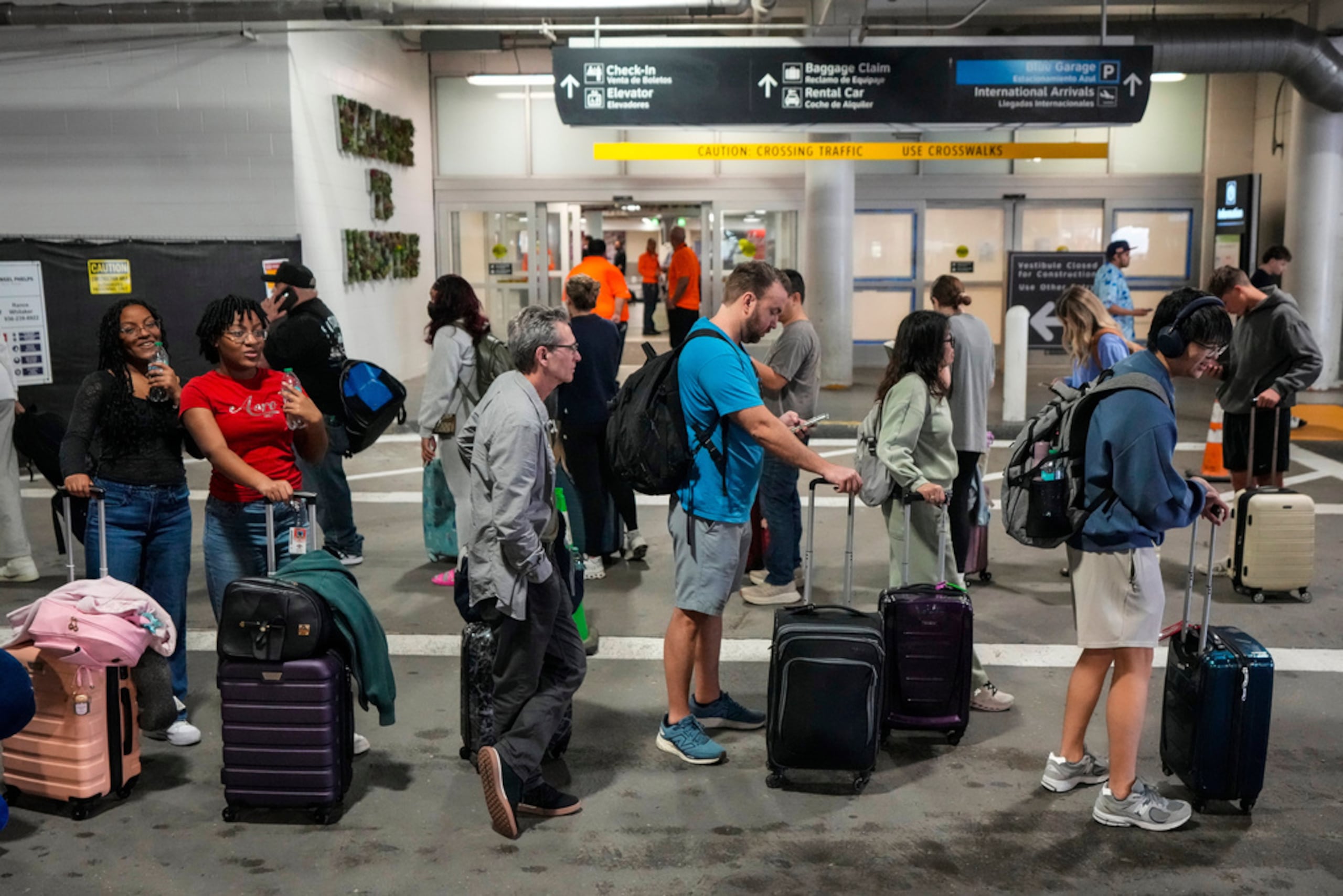 Pasajeros de aerolínea esperan en largas filas fuera de la terminal para pasar por el control de seguridad de TSA en el Aeropuerto William P. Hobby en Houston, el domingo 8 de marzo de 2026.