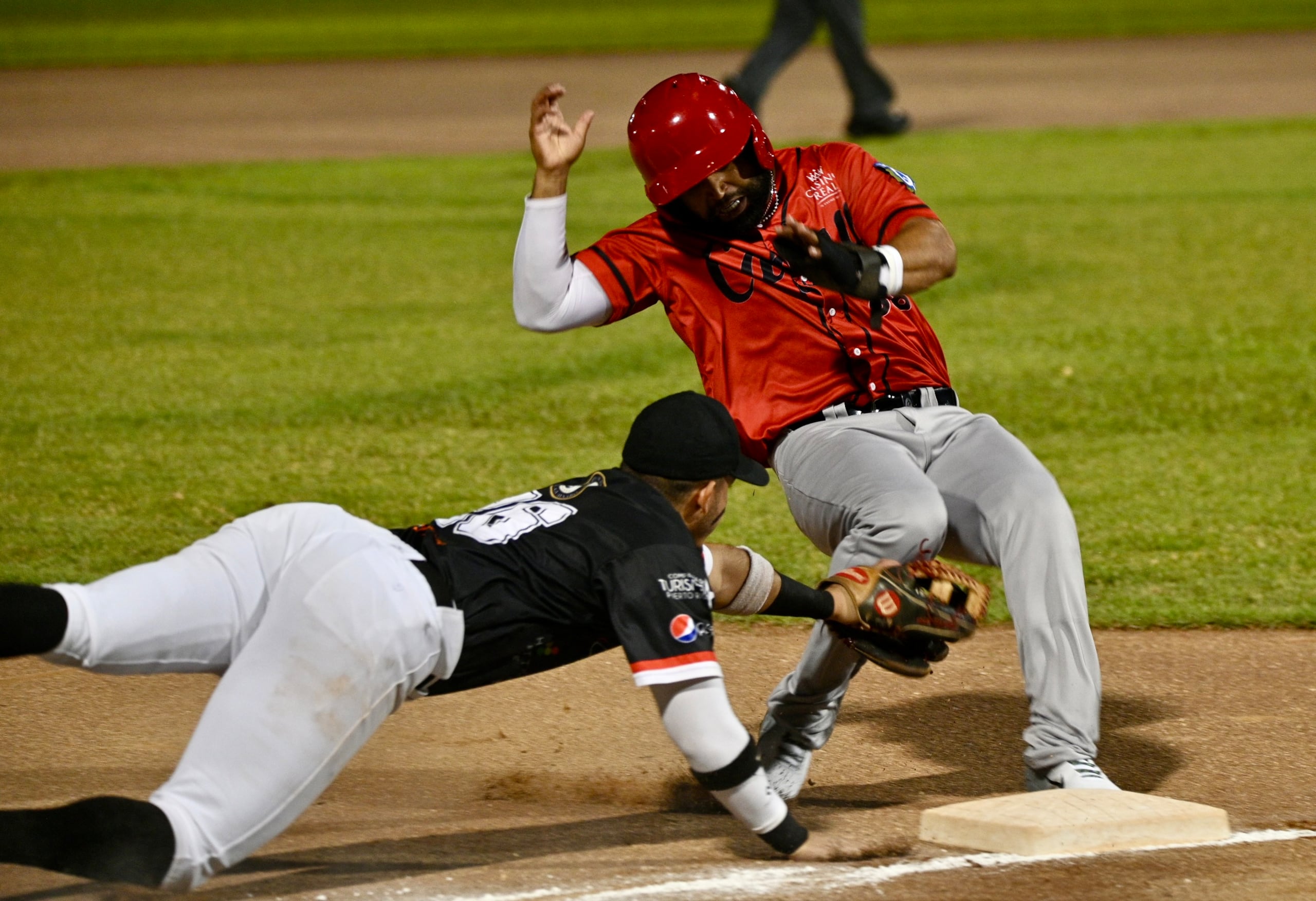 Edwin Arroyo evita ser sacado de circulación en tercera base durante el encuentro contra los Mets de Guaynabo.