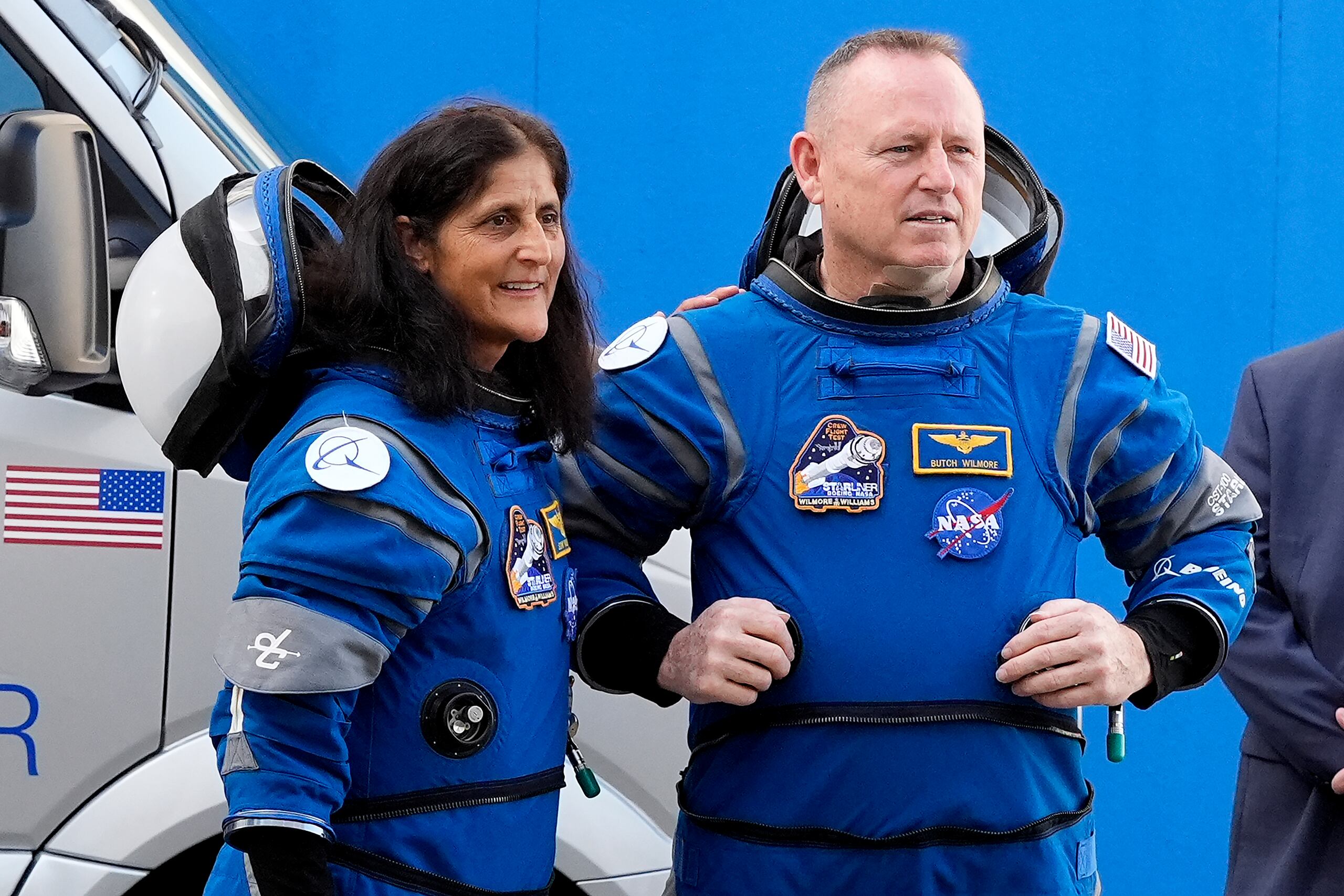 Los astronautas de la NASA Suni Williams, izquierda, y Butch Wilmore hablan con miembros de la familia mientras abandonan el edificio de operaciones para un viaje a la plataforma de lanzamiento.