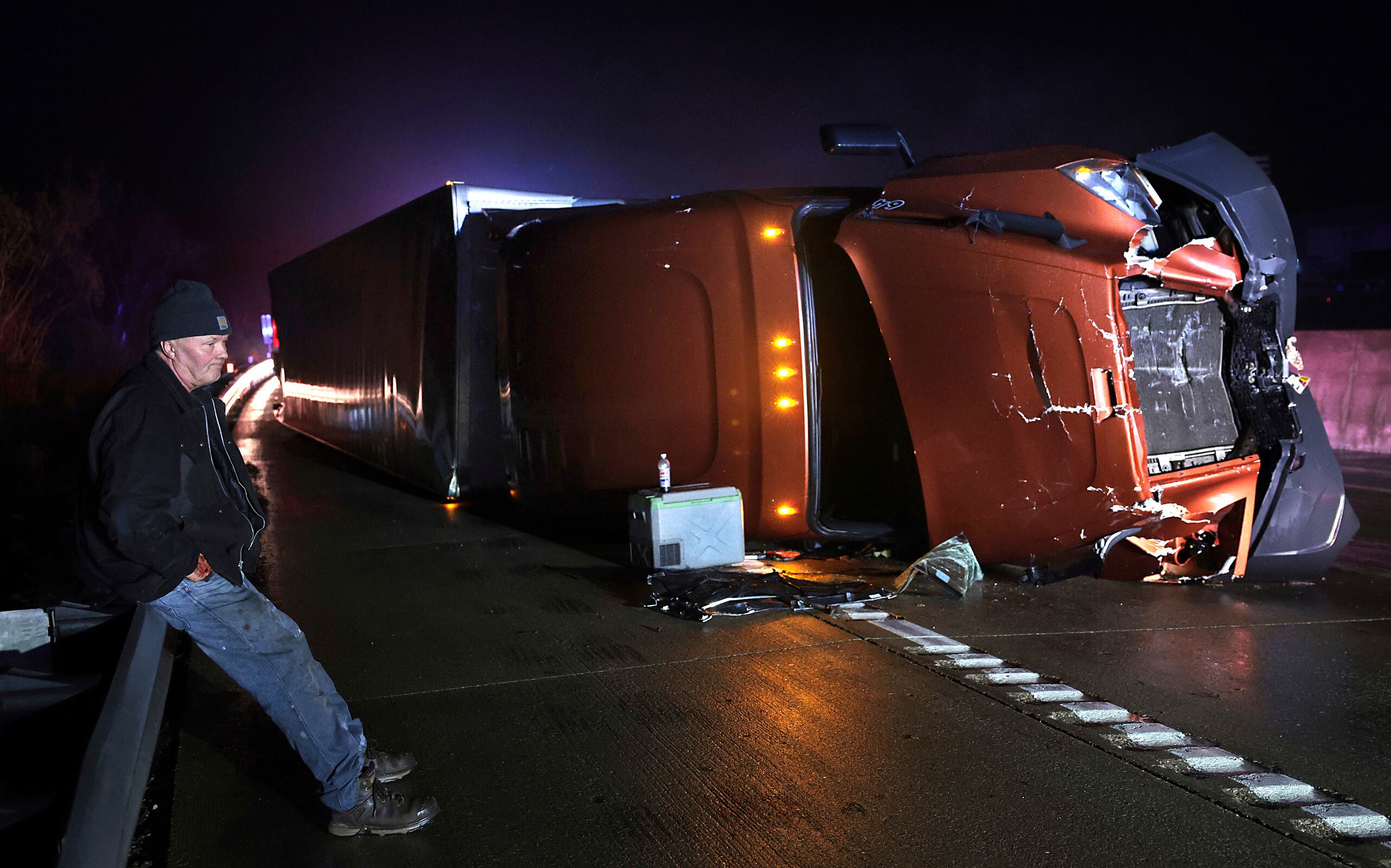 Mark Nelson, de Wisconsin, espera junto a su tráiler, que volcó durante un episodio de potentes vientos y un posible tornado en la carretera interestatal 44 en dirección oeste en Villa Ridge, Missouri, el 14 de marzo de 2025. (Robert Cohen/St. Louis Post-Dispatch vía AP)
