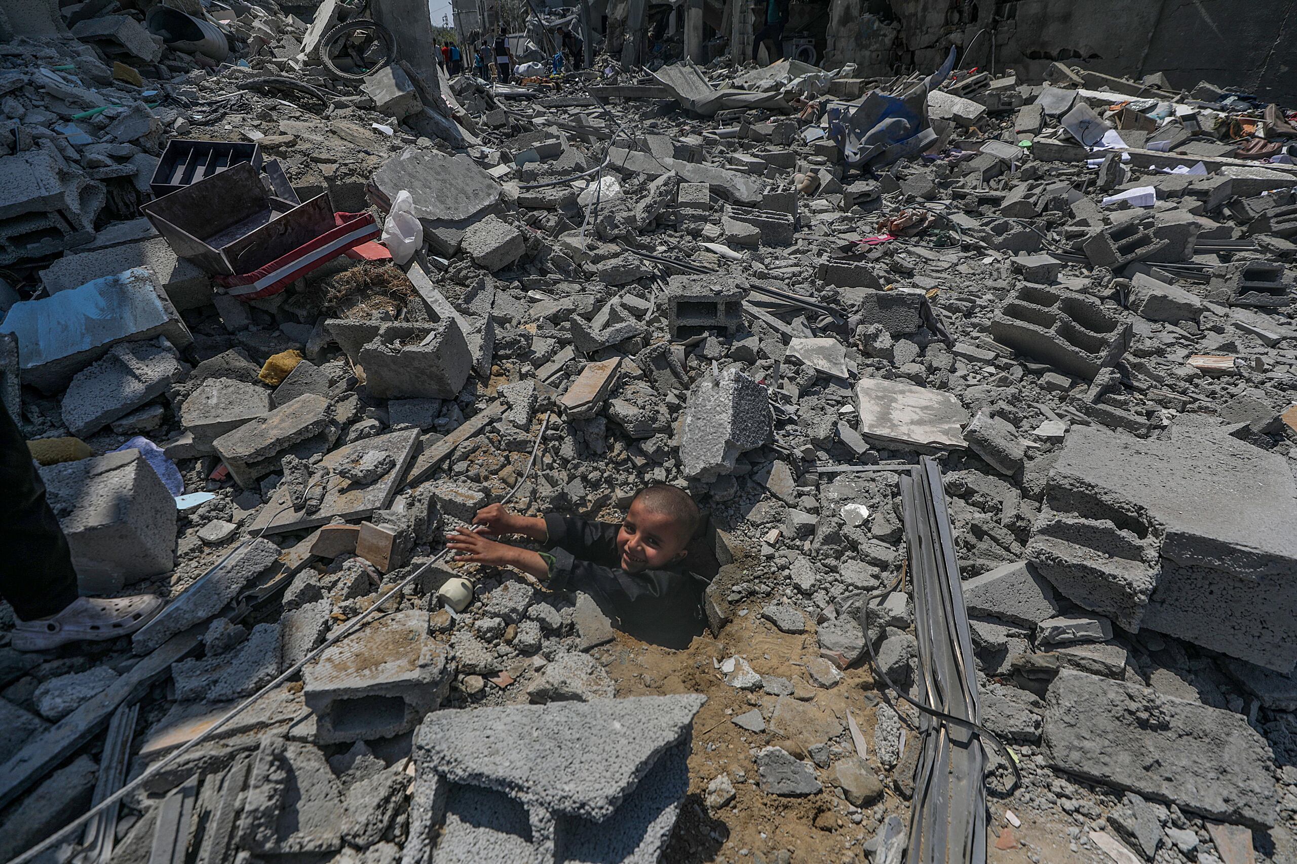 Un niño palestino juega entre los escombros de su casa destruida en el campo de refugiados de Al Maghazi, en el centro de la Franja de Gaza, el 15 de abril de 2024. (EFE/EPA/MOHAMMED SABLE)