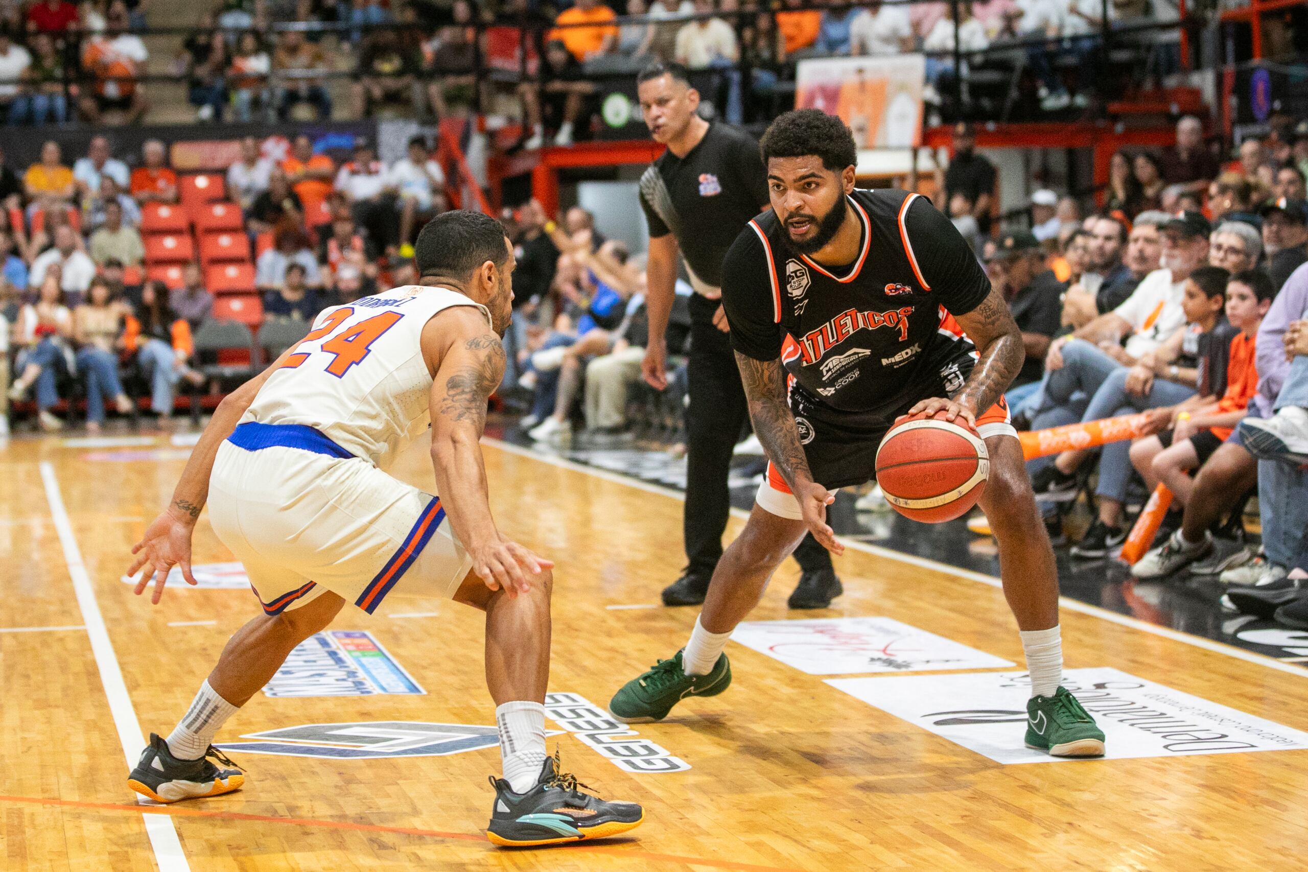 E.J. Crawford, de los Atléticos, maneja el balón contra Angel Rodríguez, de los Cangrejeros.
