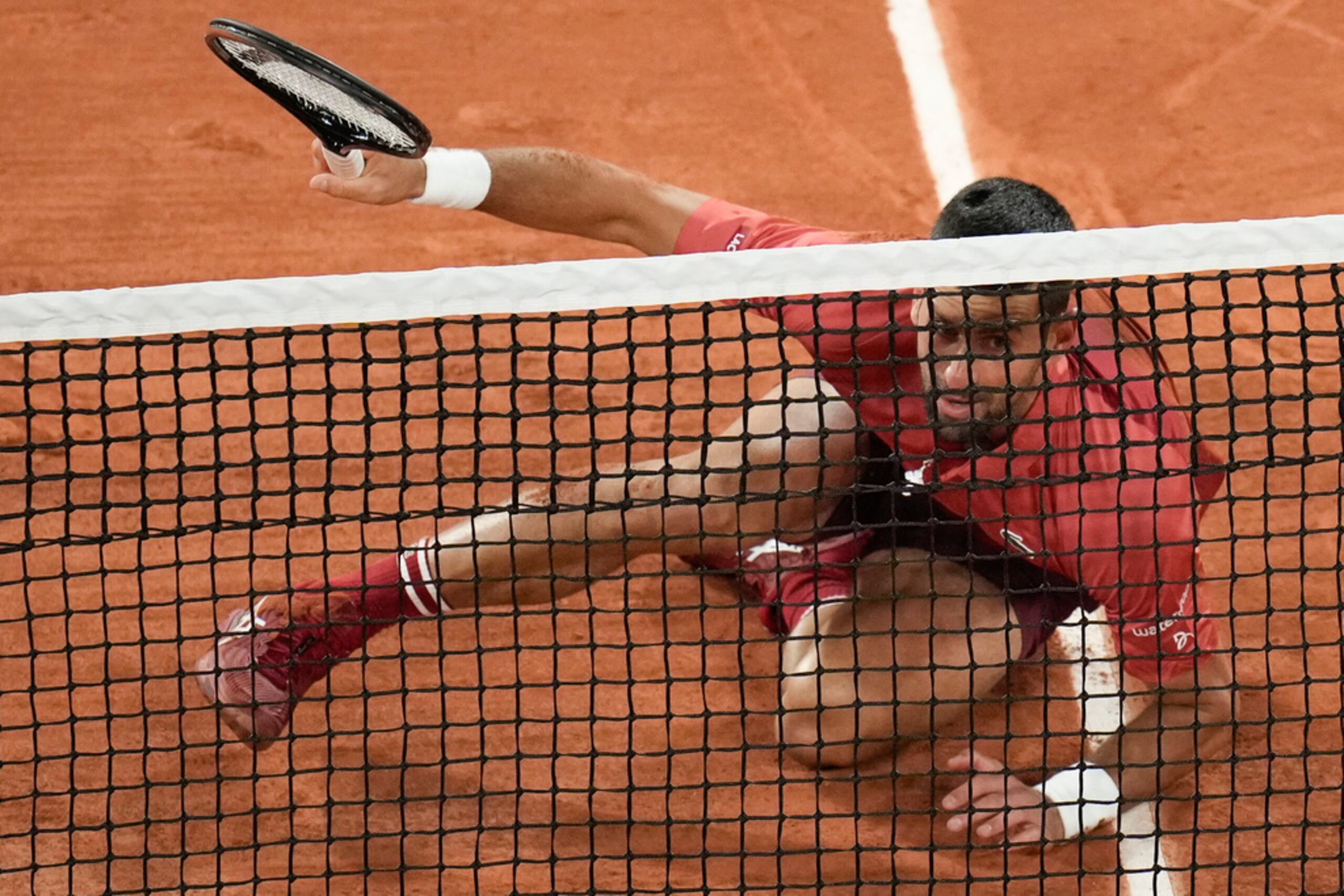 Novak Djokovic cae al suelo durante el partido de primera ronda contra el francés Pierre-Hugues Herbert en el estadio Roland Garros.
