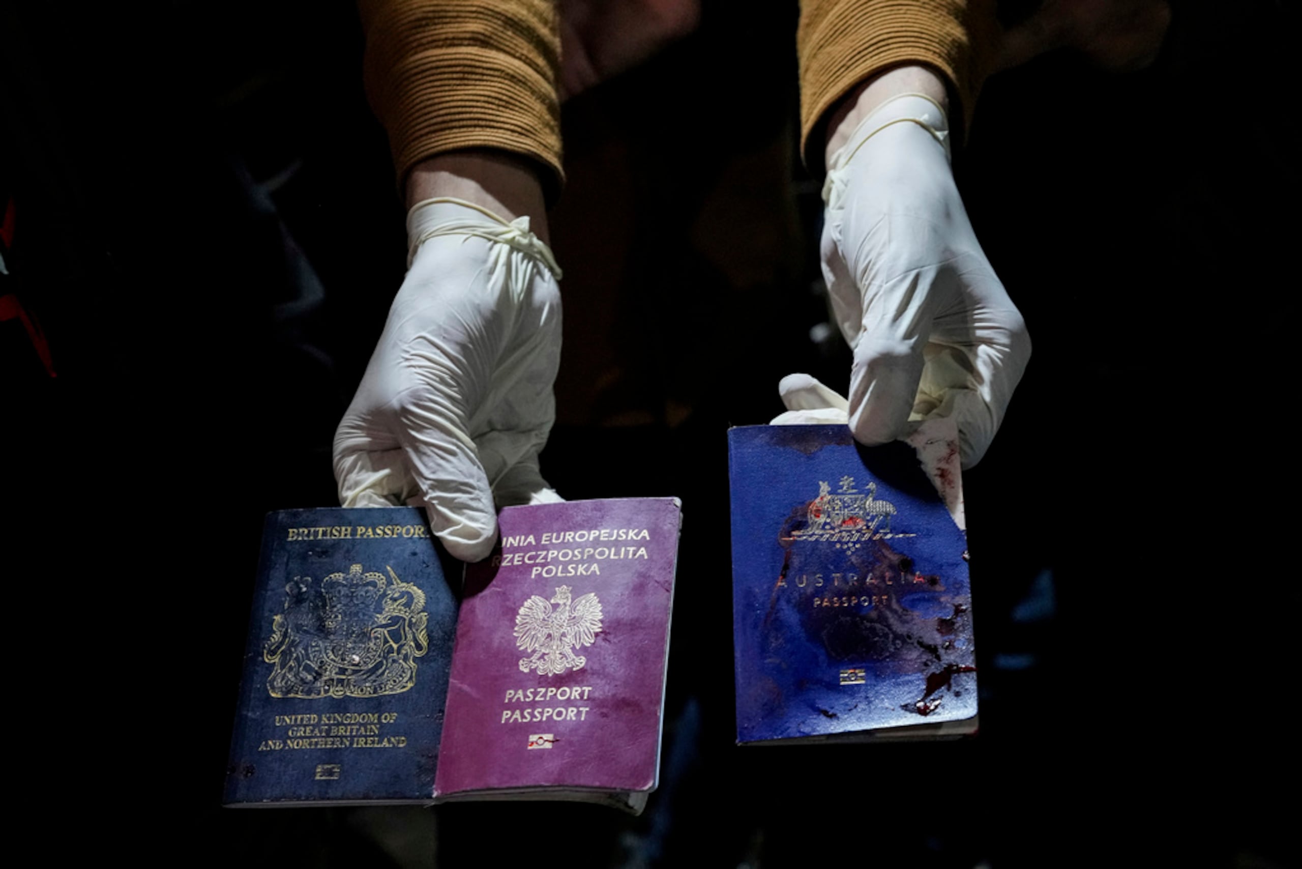 Un hombre muestra pasaportes británicos, polacos y australianos manchados de sangre después del ataque aéreo israelí en Deir al-Balah, Franja de Gaza, el 1 de abril de 2024.