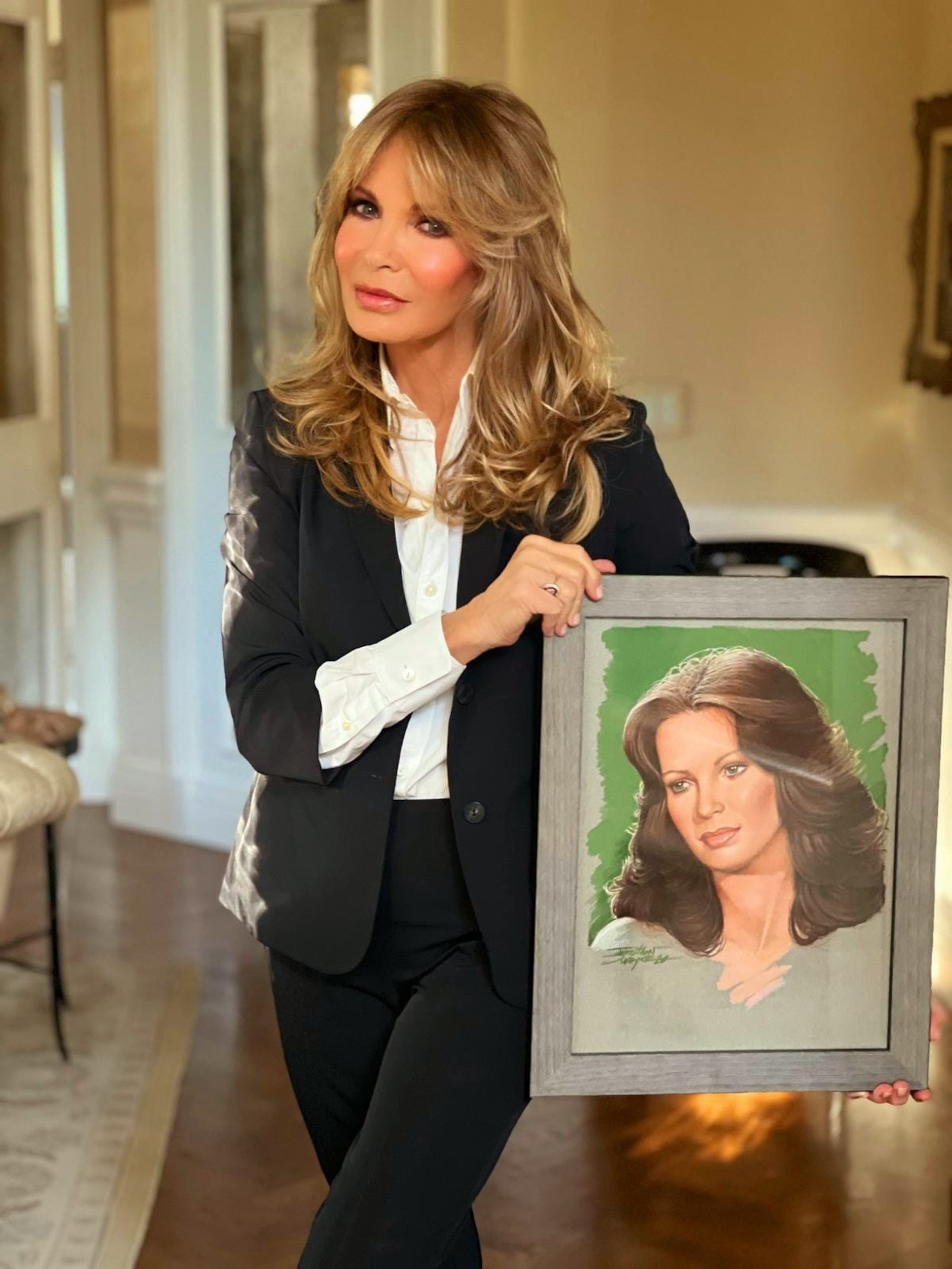 Jaclyn Smith junto al retrato suyo que realizó Jonathan Dwayne.