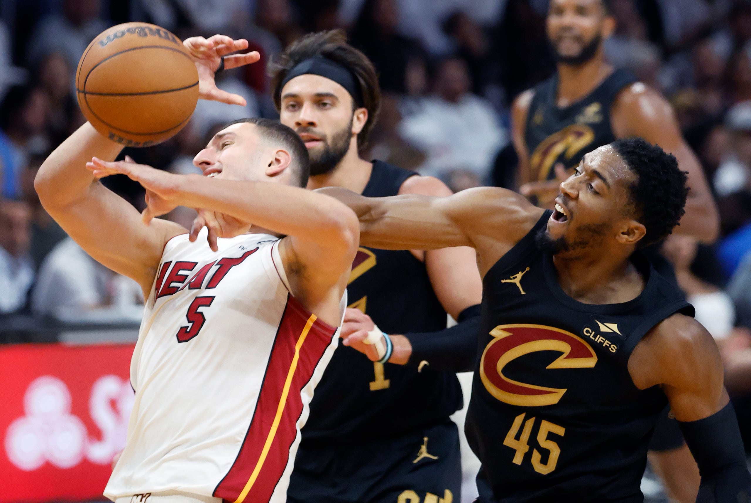 Donovan Mitchell (45) le pega una fuerte falta personal al delantero del Heat de Miami, Nikola Jovic (5), durante la acción del partido del lunes.