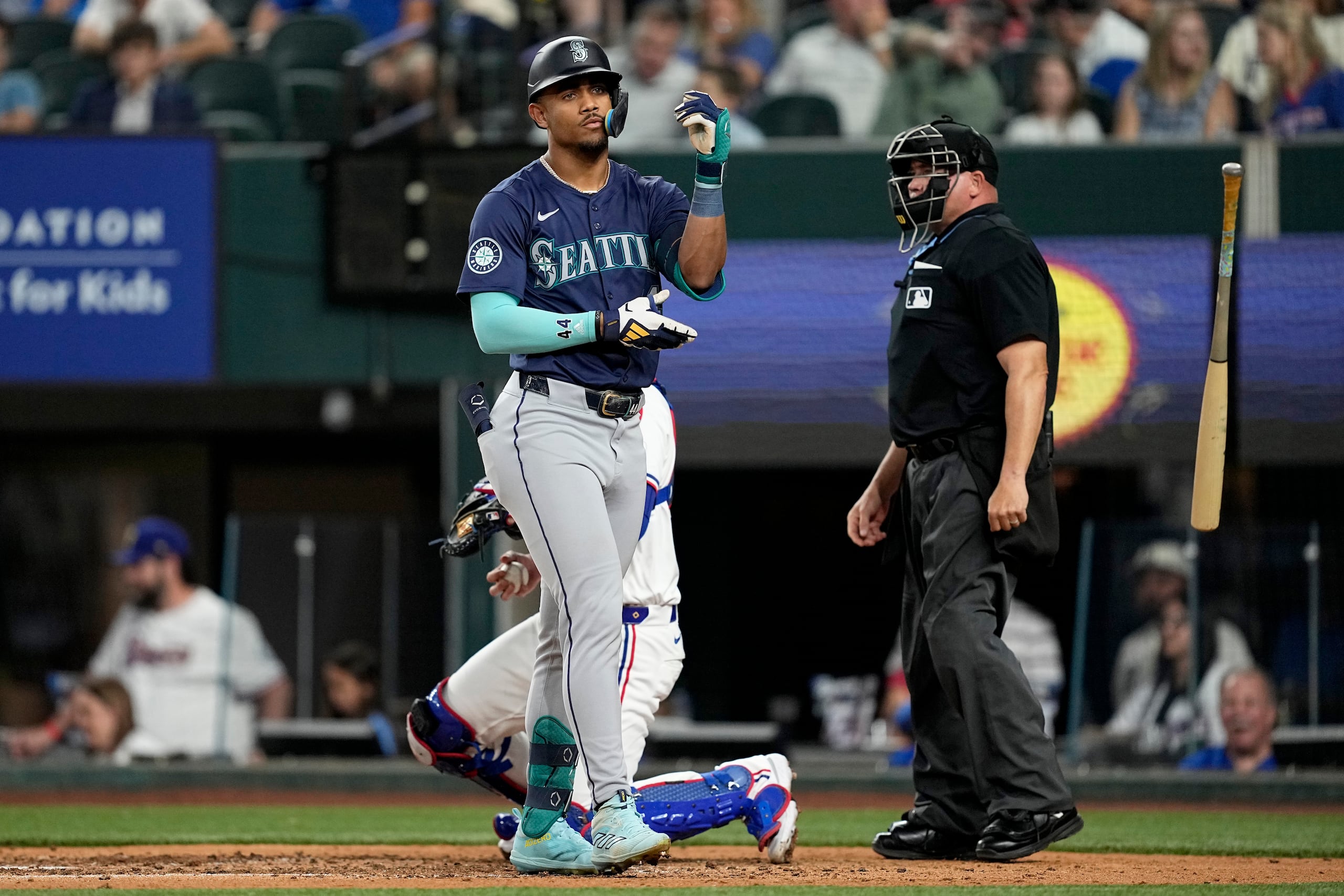 El dominicano Julio Rodríguez, de los Marineros de Seattle, lanza su bate tras recibir un boleto en el encuentro del martes 23 de abril de 2024, ante los Rangers de Texas (AP Foto/Tony Gutiérrez)