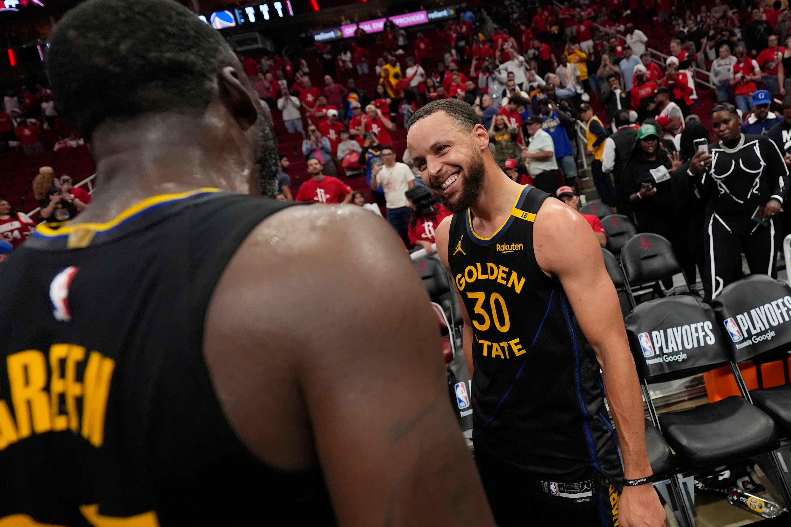 Stephen Curry (30) y Draymond Green, de los Warriors de Golden State, celebran después del Juego 7 de una serie de primera ronda de playoffs de baloncesto de la NBA contra los Rockets de Houston, el domingo 4 de mayo de 2025, en Houston. (AP Foto/Ashley Landis)