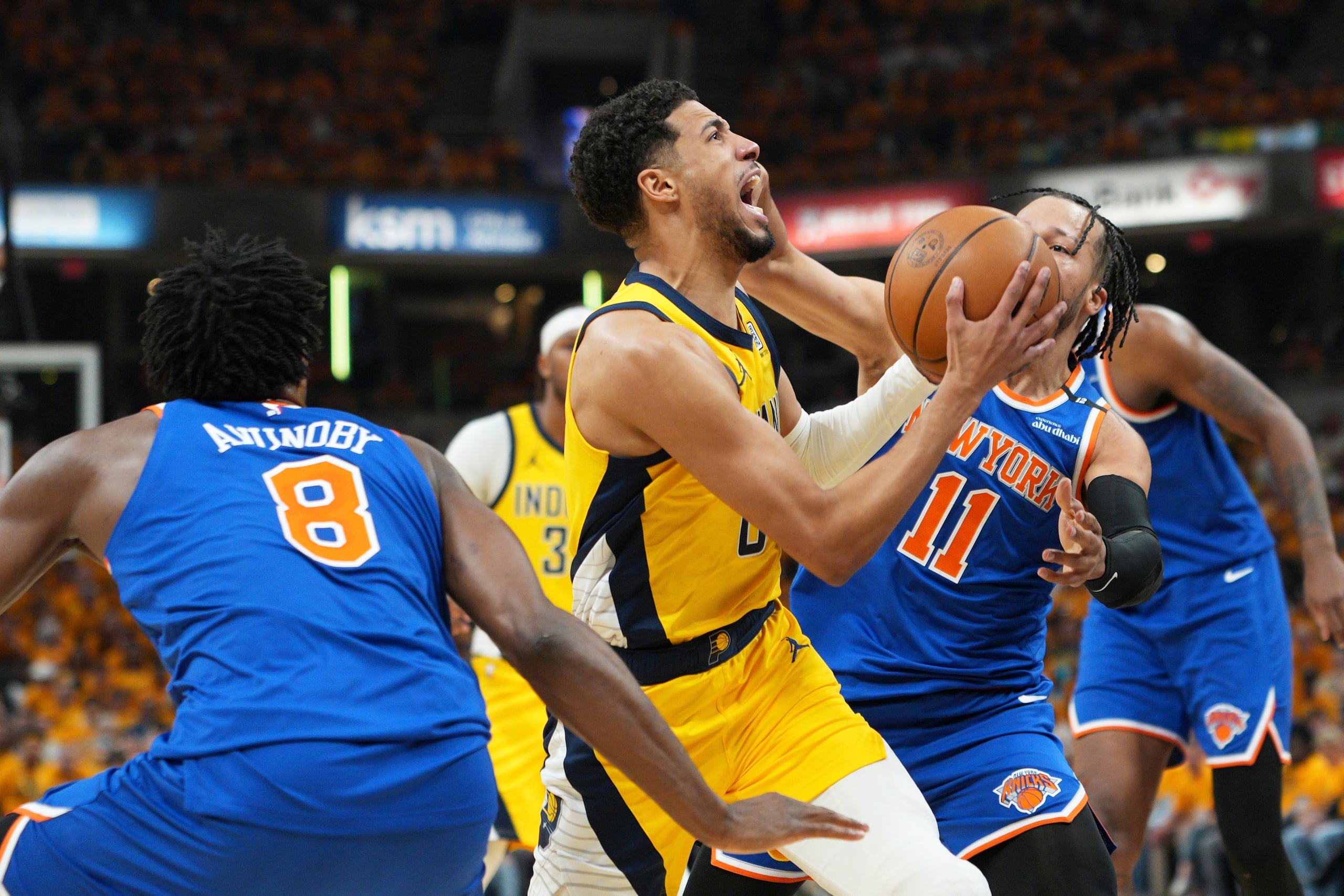 Tyrese Haliburton, centro, busca atacar la canasta contra OG Anunoby (8) y Jalen Brunson (11), de los Knicks de Nueva York, durante la primera mitar del tercer juego de la final de la Conferencia Este del baloncesto de la NBA.