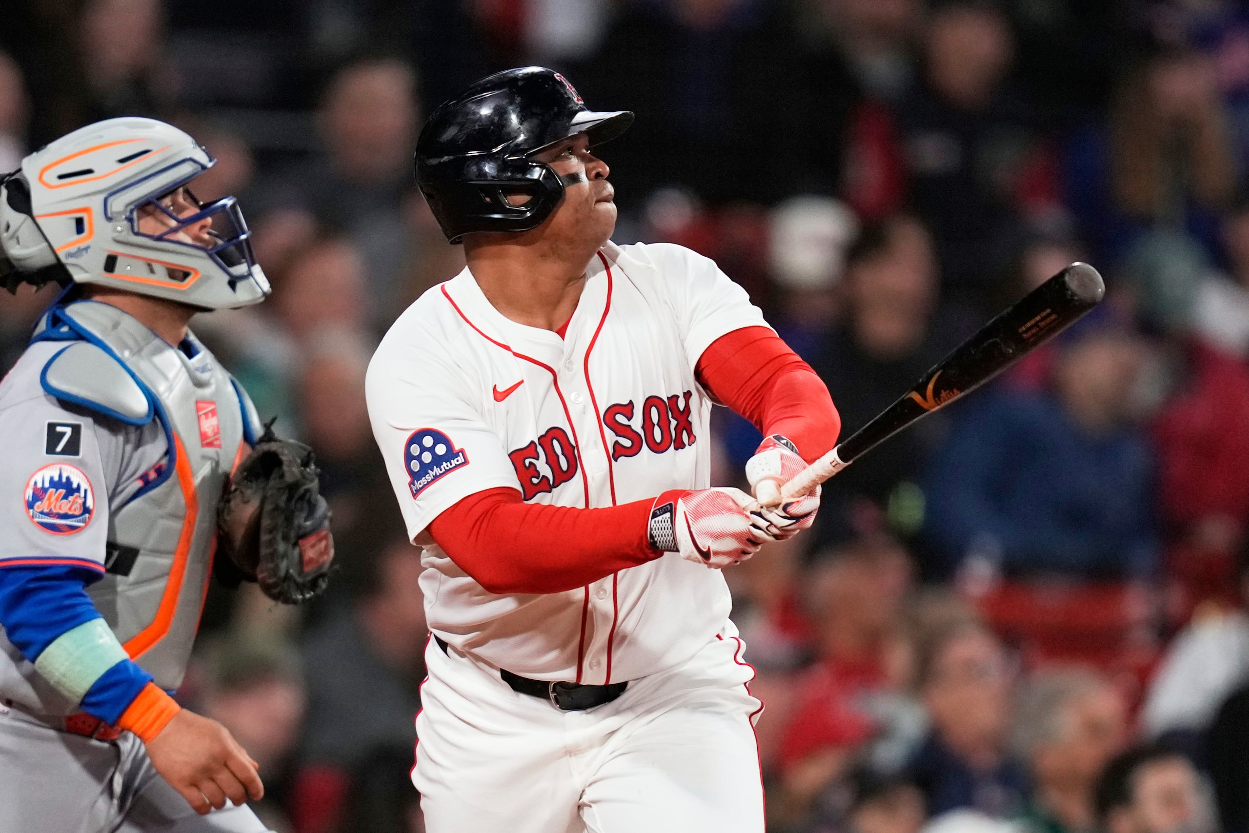 El bateador designado de los Medias Rojas de Boston, Rafael Devers, observa el vuelo de su jonrón solitario durante la quinta entrada de un juego de béisbol contra los Mets de Nueva York en el Fenway Park.