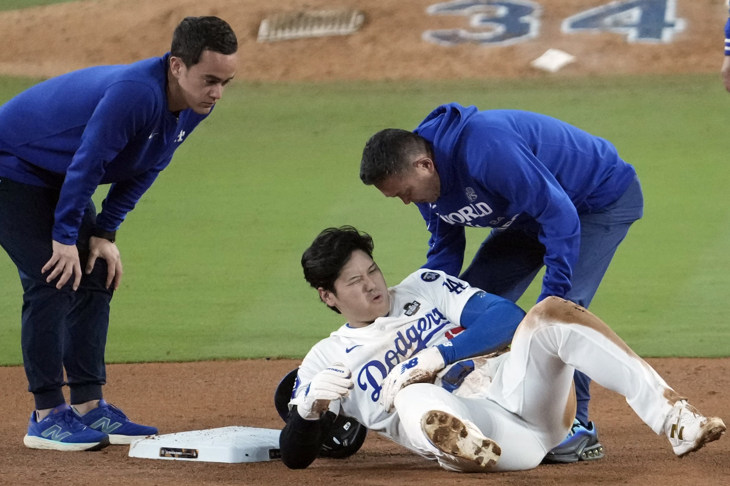 Personal médico de los Dodgers verifica a Shohei Ohtani, quien se latimó en un intento de robo de base.