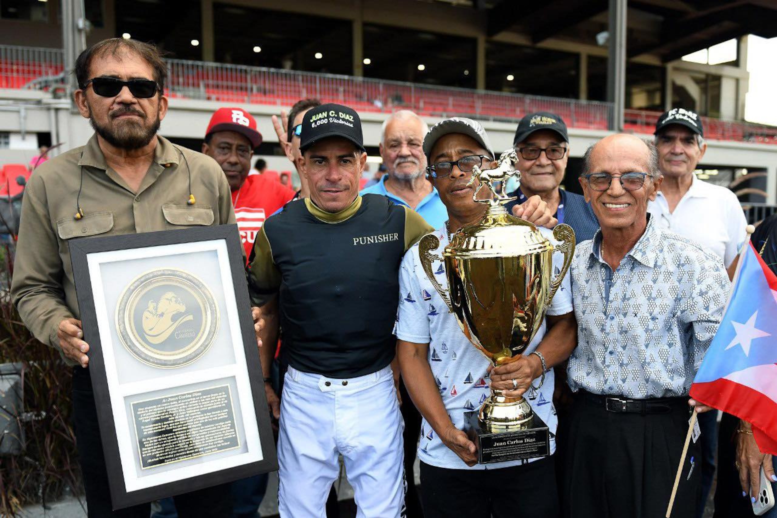 Juan Carlos Díaz posa con piezas de reconocimiento que recibió tras el logro.