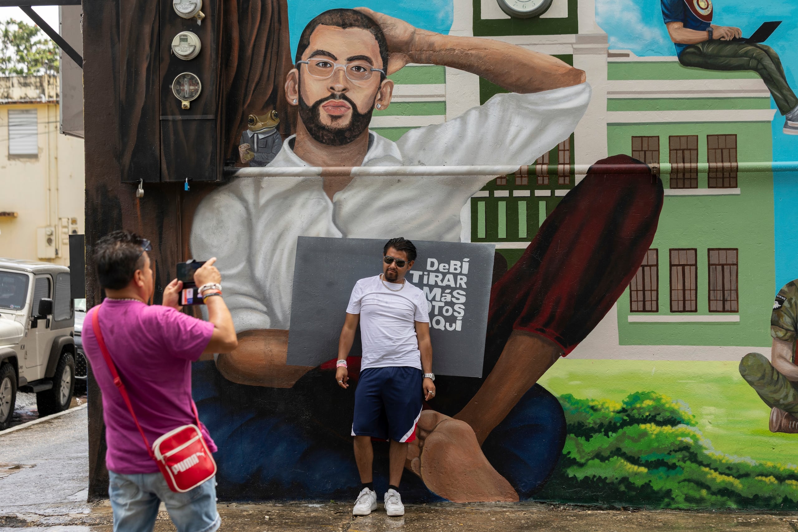 Un participante en una visita guiada posa para una foto delante de un mural de Bad Bunny en Vega Baja, Puerto Rico, el 12 de agosto de 2025. (AP Foto/Alejandro Granadillo)