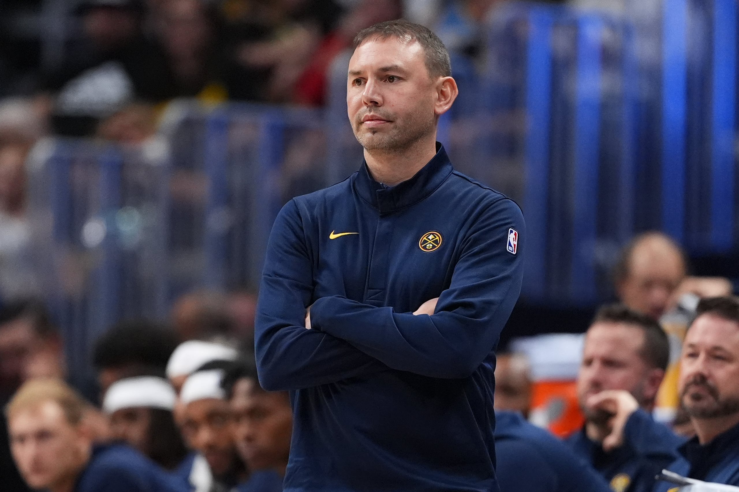 El entrenador de Denver, David Adelman,  mira al partido, como también lo hace su asistente, el boricua José Juan Barea, detrás de él fuera de foco.