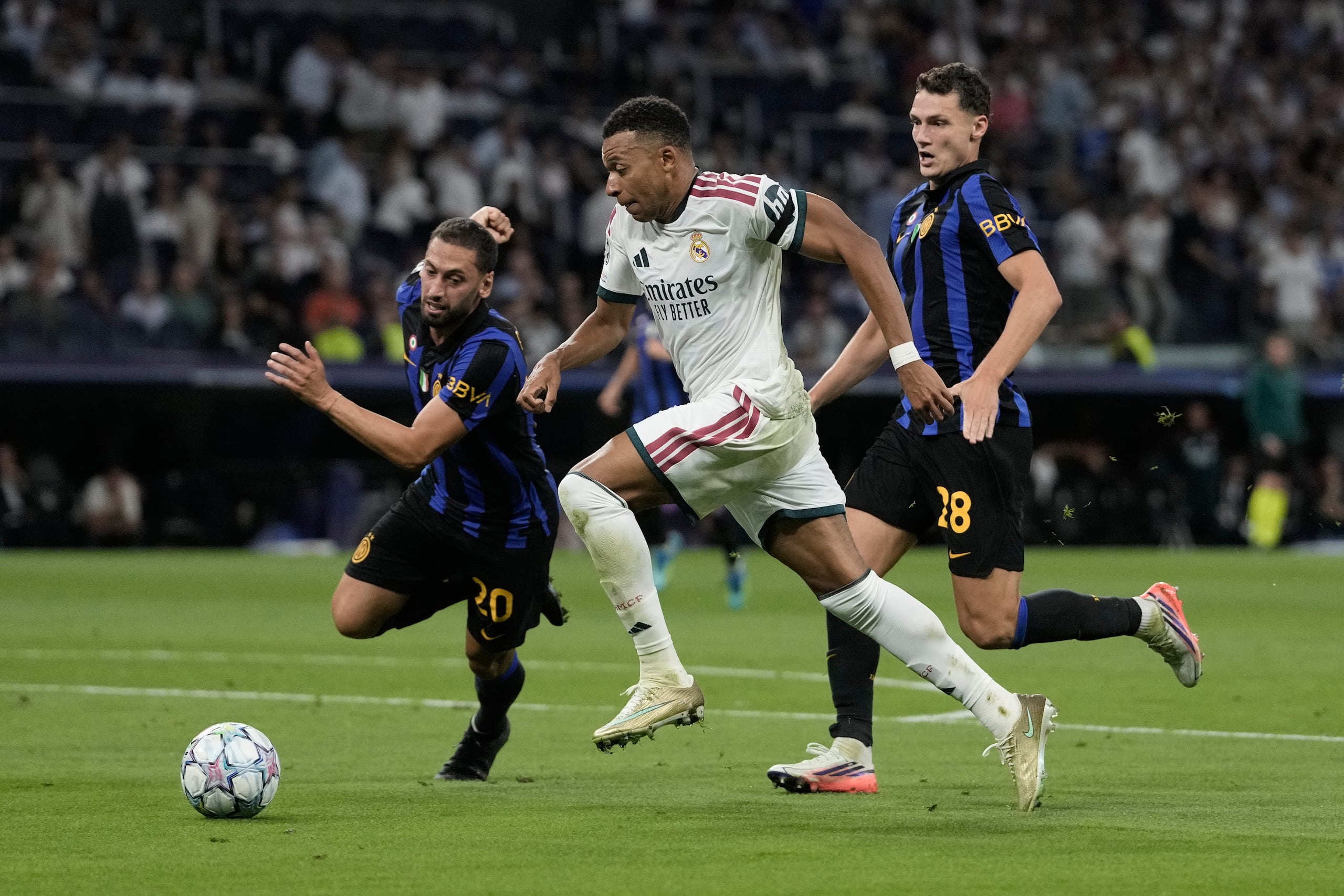 Kylian Mbappe del Real Madrid pelea por el balón con Benjamin Pavard y Hakan Calhanoglu del Inter de Milán en la Liga de Campeones el martes 8 de septiembre del 2026. (AP Foto/Bernat Armangue)