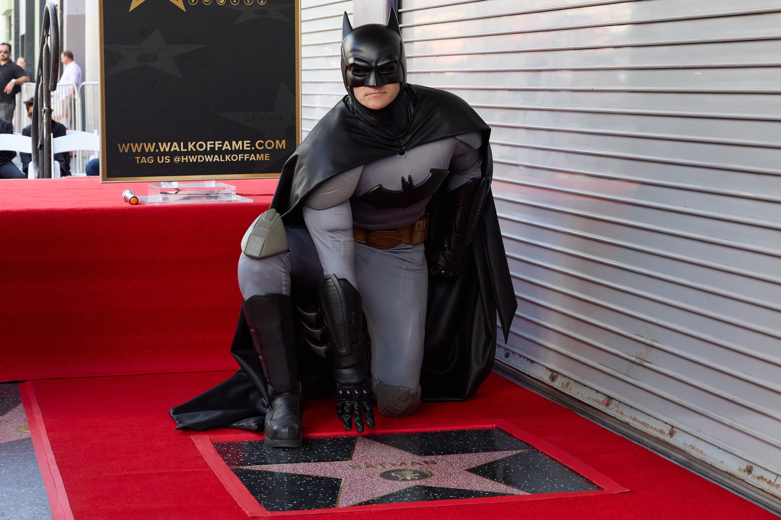 Un actor que se hace pasar por el personaje de Batman se arrodilla sobre su recién inaugurada estrella en el Paseo de la Fama de Hollywood después de una ceremonia en honor al superhéroe en Los Ángeles, California, EE.UU. EFE/EPA/ALLISON DINNER