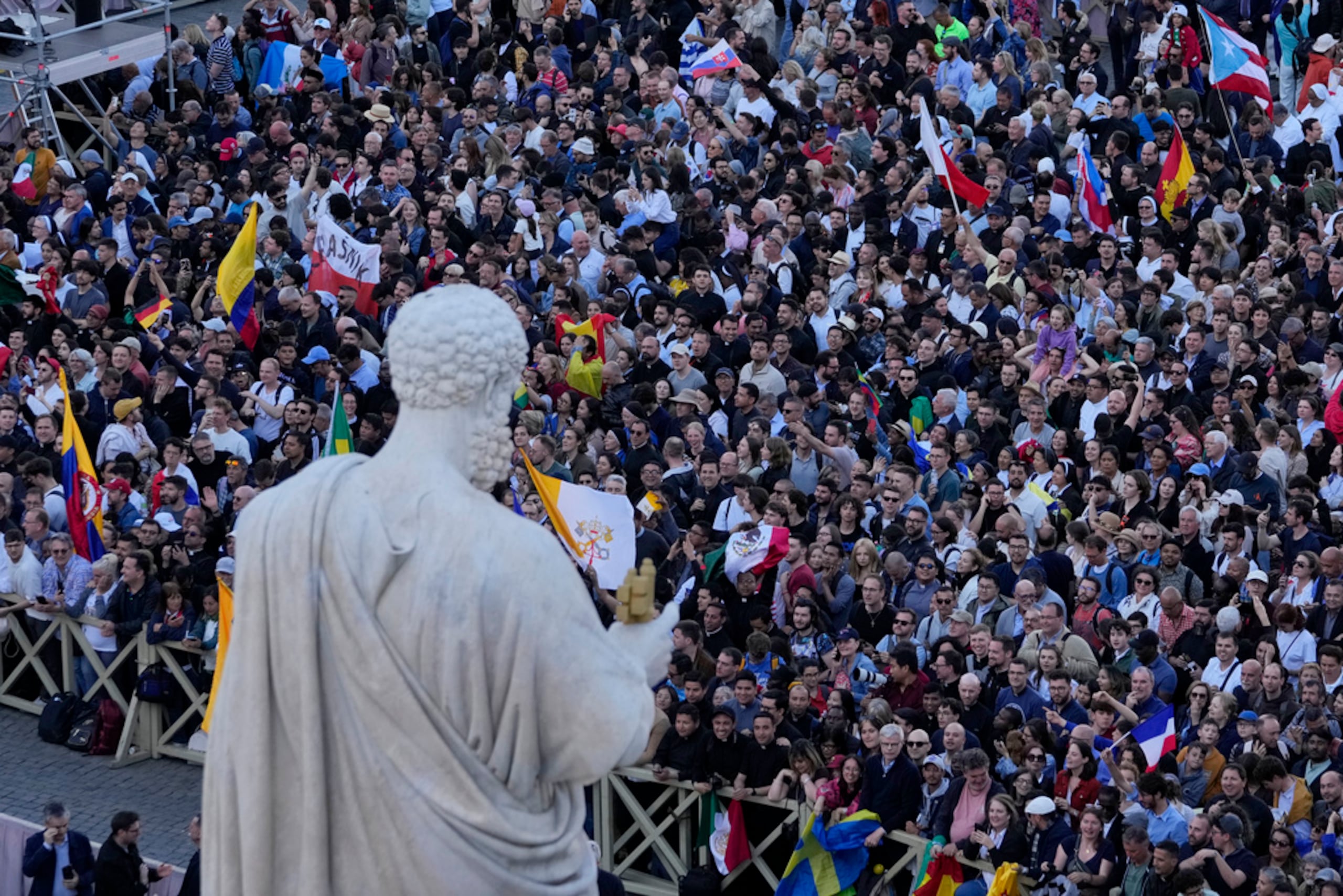 Personas ondean banderas en la plaza de San Pedro tras la elección del pontífice número 267 de la Iglesia católica romana, en el Vaticano, el jueves 8 de mayo de 2025.