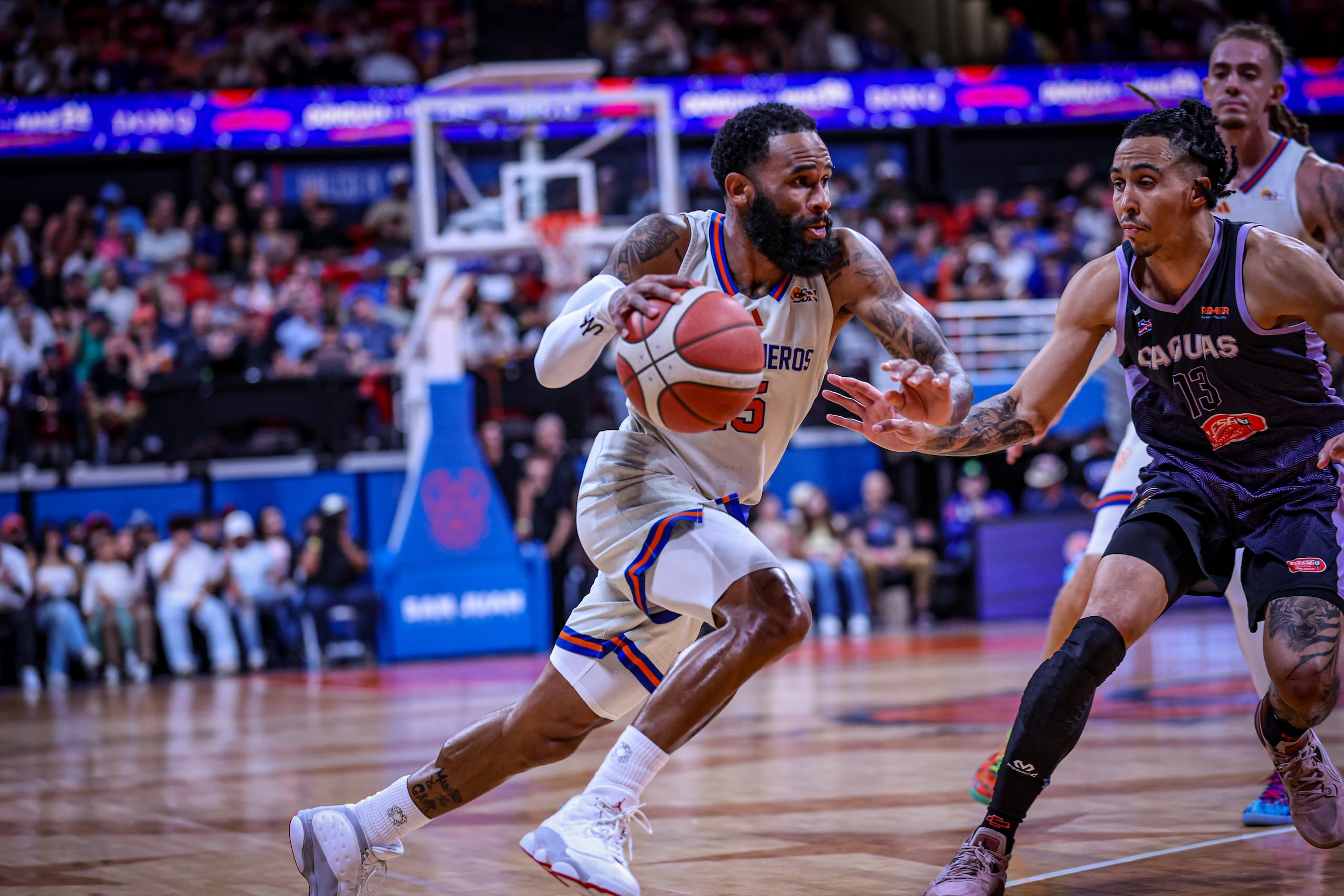 Walter Hodge Jr., de los Cangrejeros de Santurce, maneja el balón ante la presión de los Criollos de Caguas.