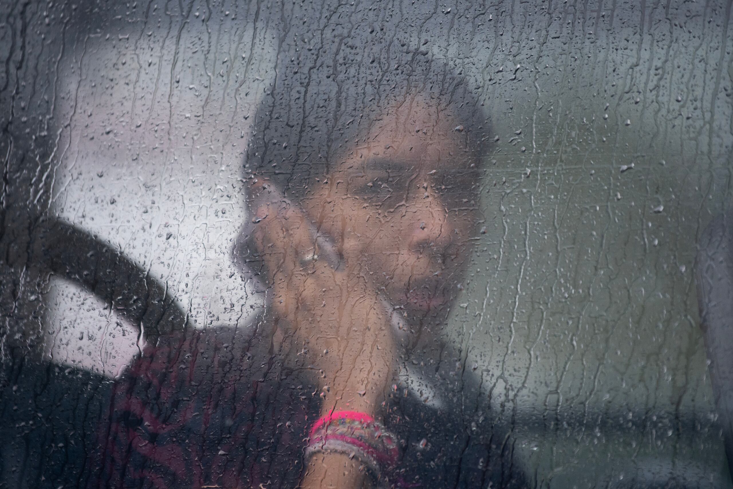 Una mujer habla por teléfono dentro de un autobús de transporte urbano que transita bajo la lluvia en la ciudad de Monterrey (México). EFE/ Miguel Sierra