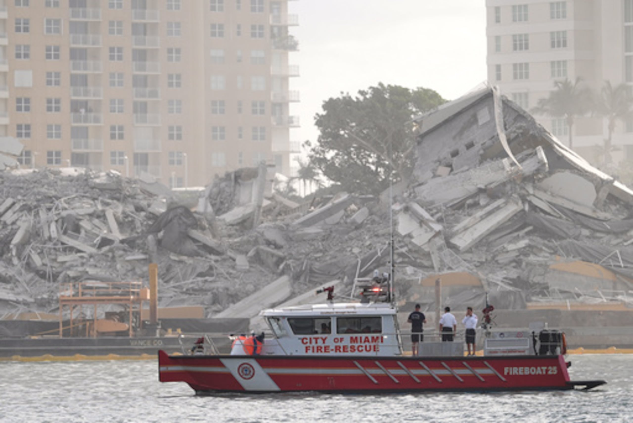 Un barco de los Bomberos de Miami examina los escombros tras la implosión controlada del antiguo hotel Mandarin Oriental en Brickell Key, el domingo 12 de abril de 2026, en Miami. (AP Photo/Rebecca Blackwell)