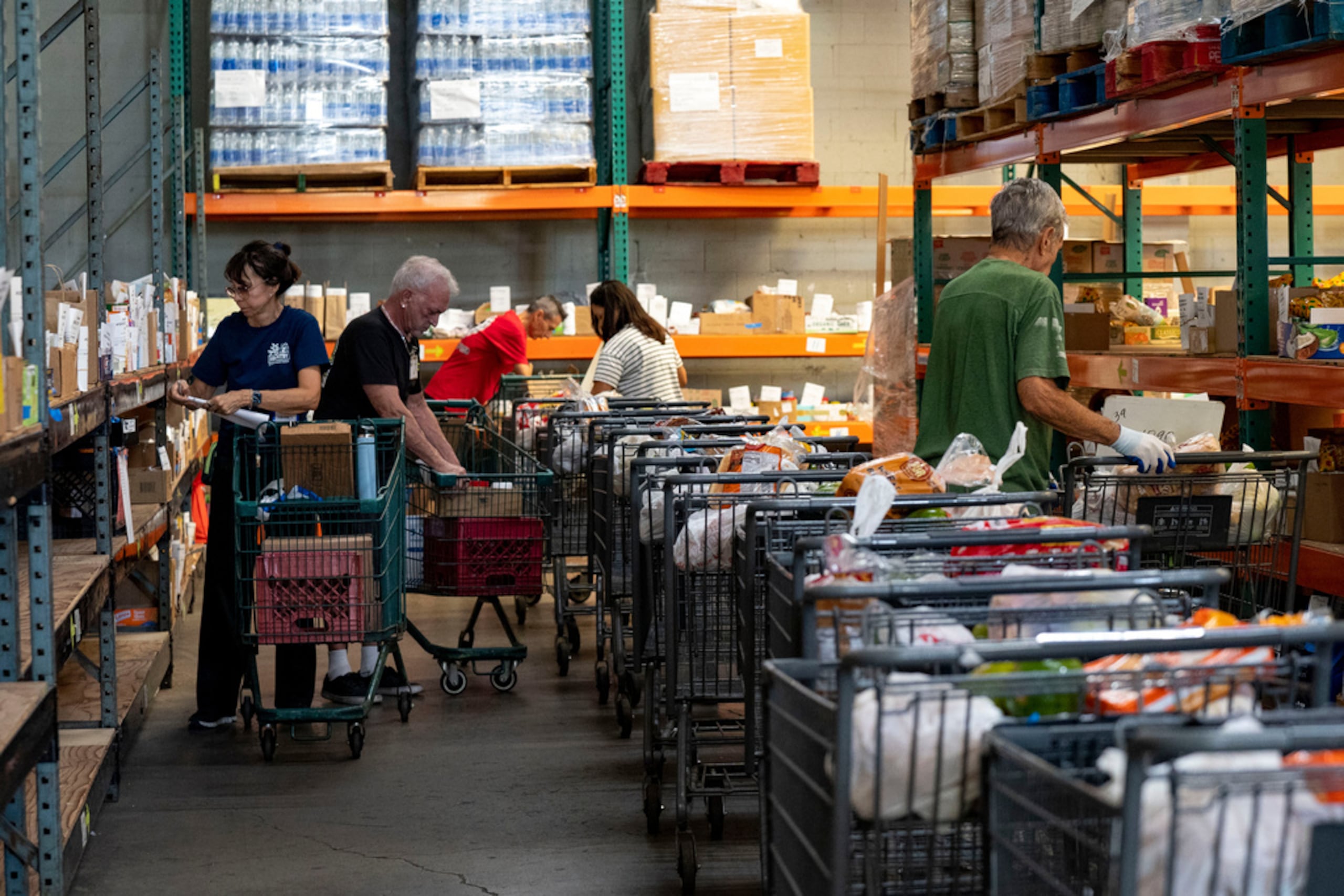 Voluntarios preparan pedidos de supermercado en línea para familias afectadas por el cierre federal en The Pantry de Feeding Hawaii Together, el 10 de noviembre de 2025, en Honolulu.