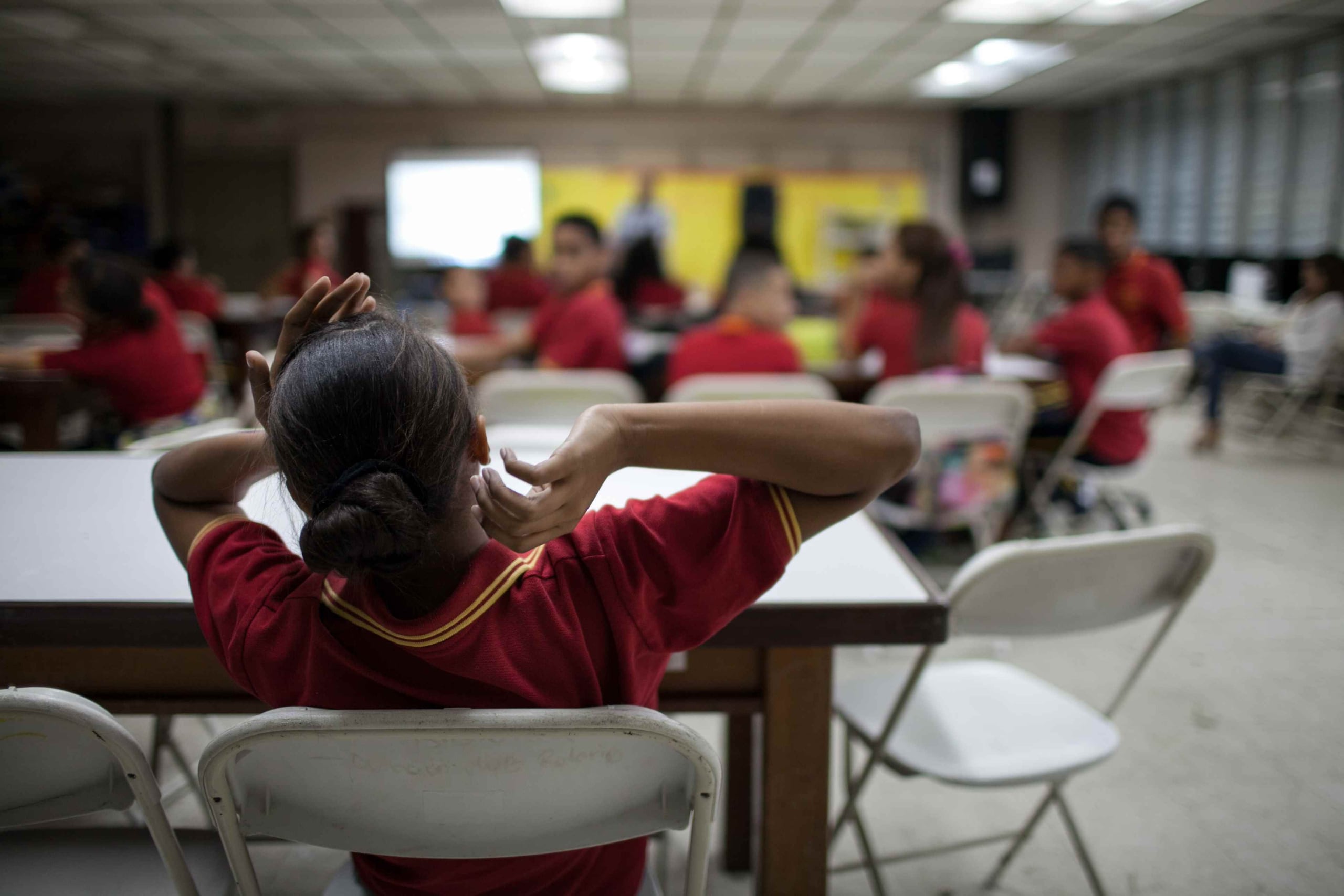 Durante la clase, varios estudiantes esconden su celular entre las libretas y escriben mensajes. Entonces, justo antes de terminar el periodo, el sonido de una canción de reguetón retumba en el salón.