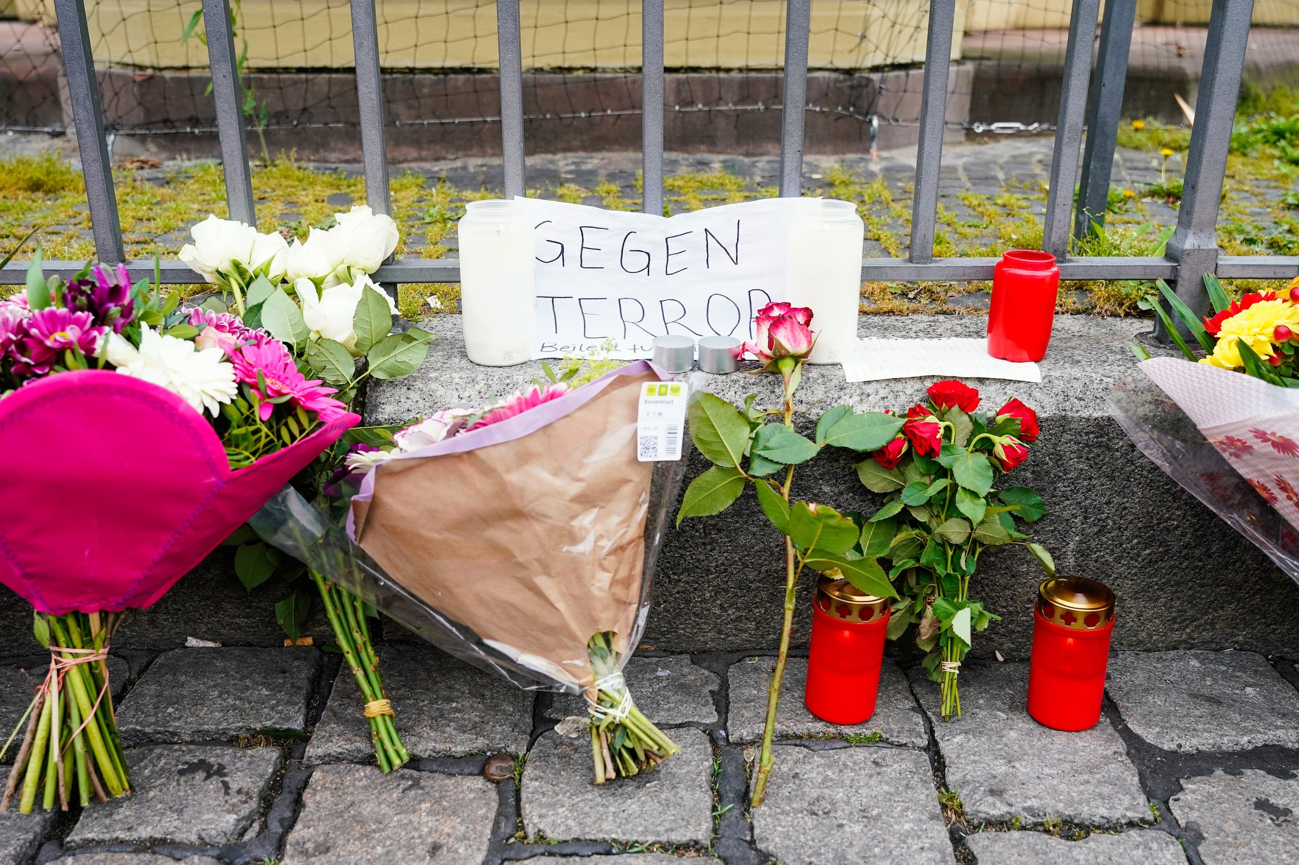 Varias personas depositaron flores y un cartel con la inscripción "Contra el terror", en la escena del crimen en la plaza del mercado de Mannheim, Alemania, donde varias personas fueron apuñaladas el viernes durante una manifestación antiislámica.