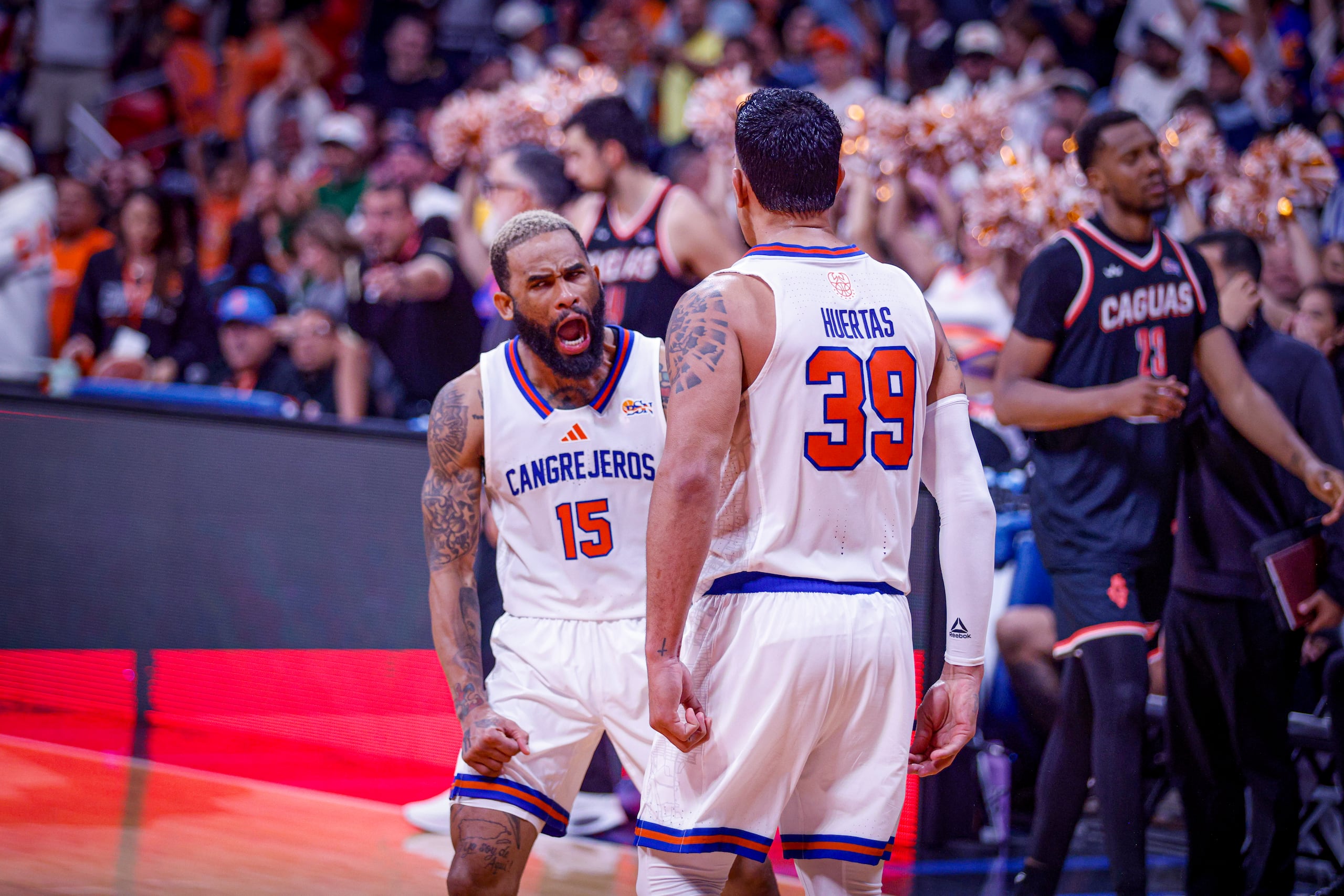 Walter Hodge Jr. y David Huertas celebran un canasto durante una victoria de los Cangrejeros de Santurce.