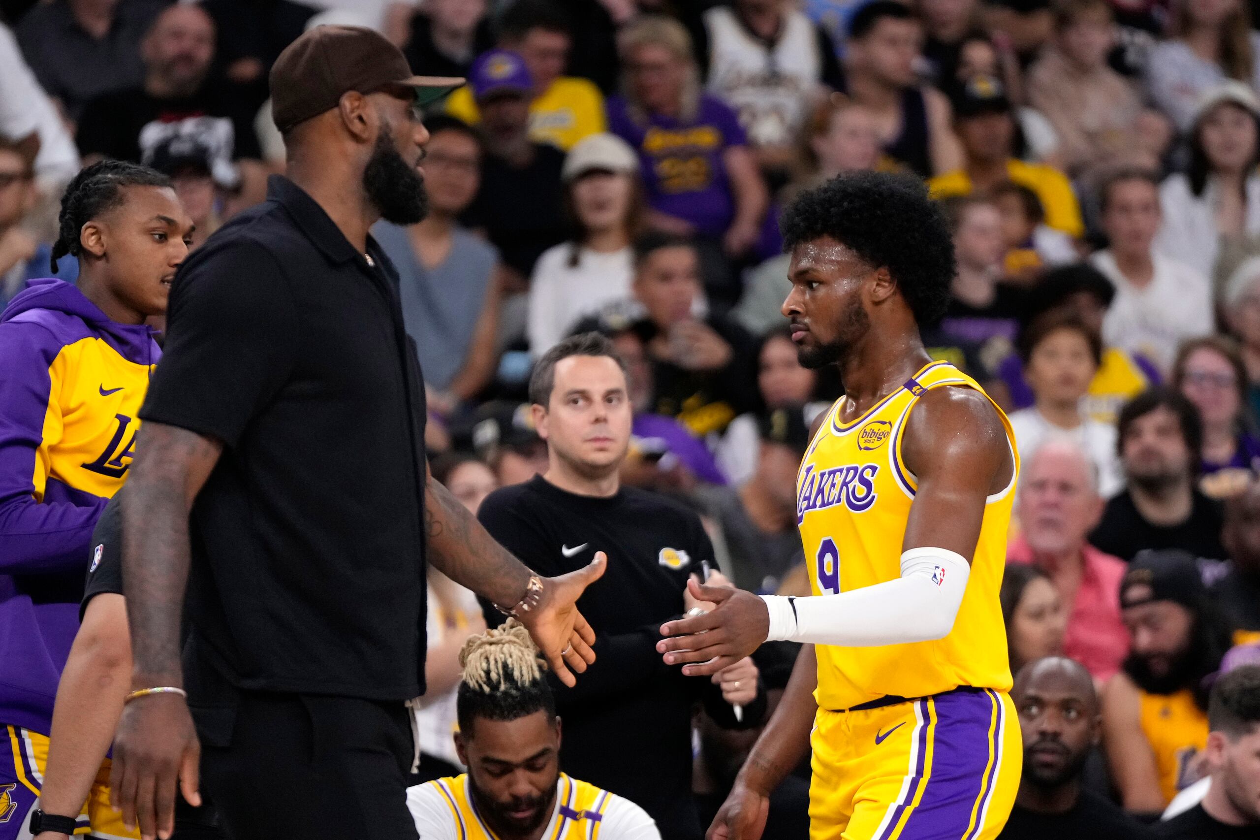 LeBron James felicita a su hijo, Bronny James, tras salir de cancha.