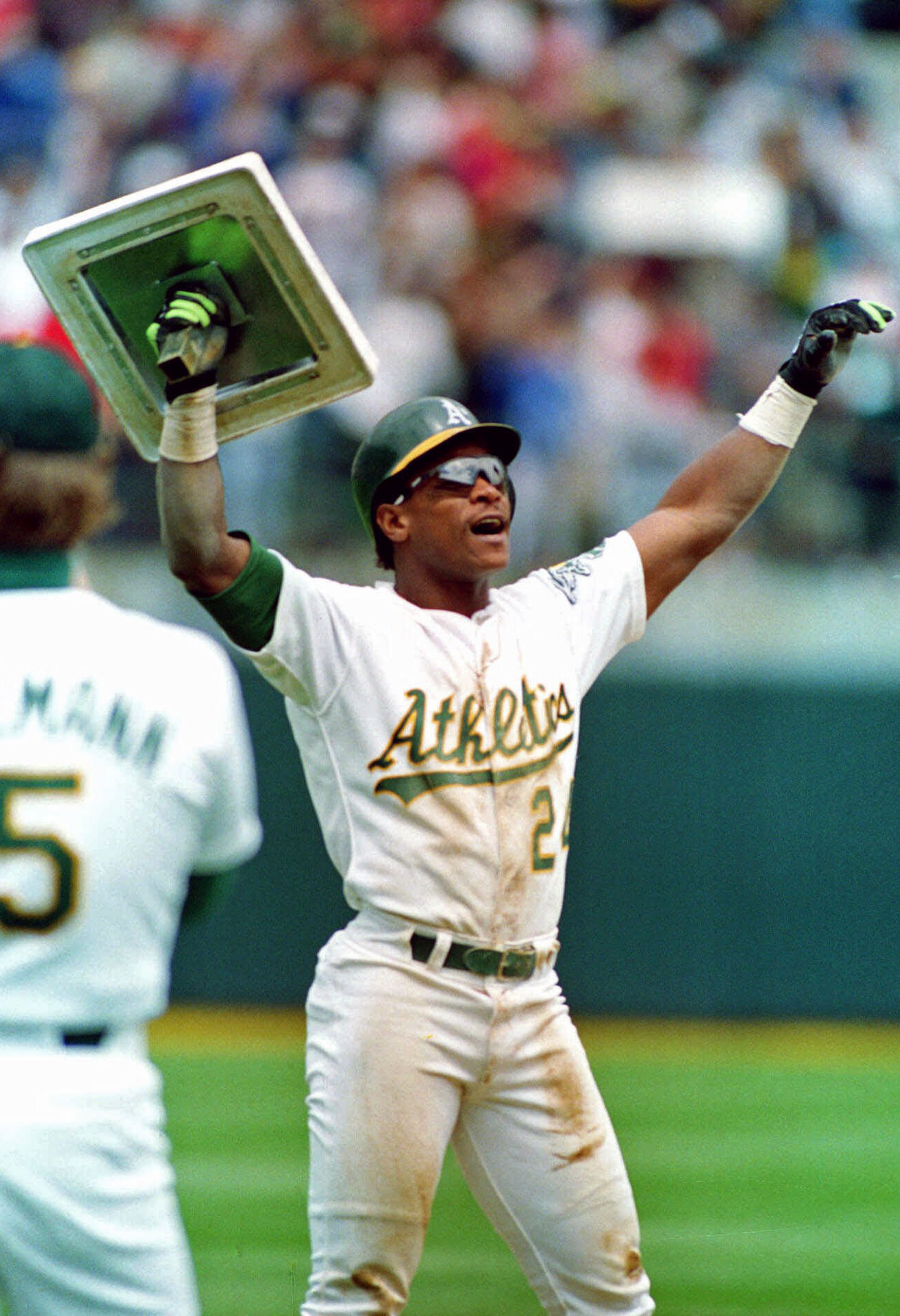 Rickey Henderson, de los Atléticos de Oakland, levanta la tercera base tras romper el récord de robos de Lou Brock en el juego ante los Yankees de Nueva York, el 1 de mayo de 1991.